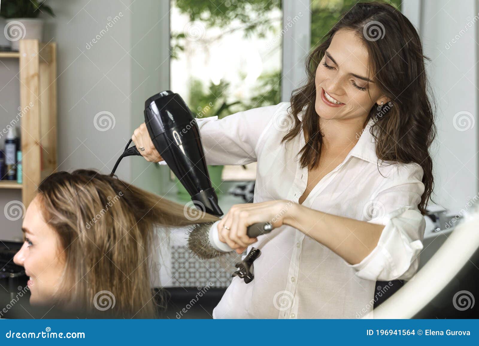 Garota cabeleireira segurando um secador de cabelo nas mãos