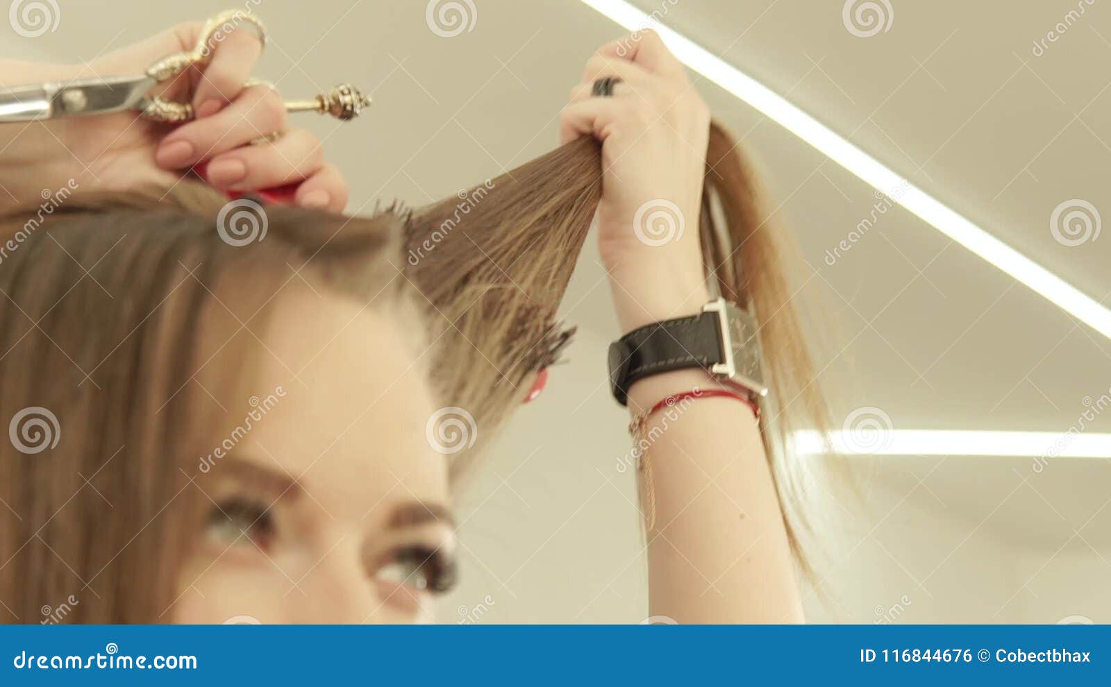 Cabeleireiro corta e penteia o cabelo com secador para senhora loira