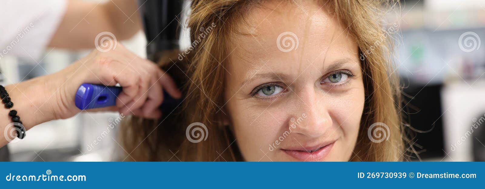 Cabeleireiro seca e modela o cabelo com um secador de cabelo no salão de  beleza