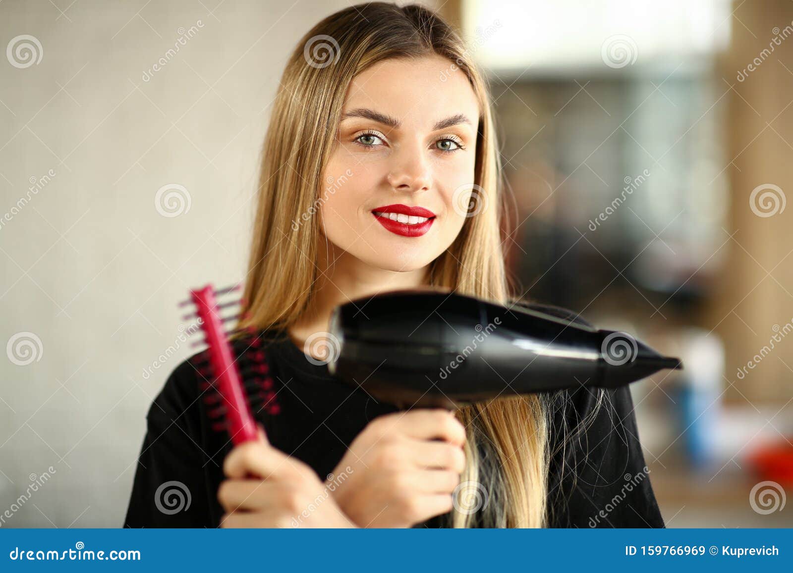 Mão feminina segurando secador de cabelo profissional isolado no