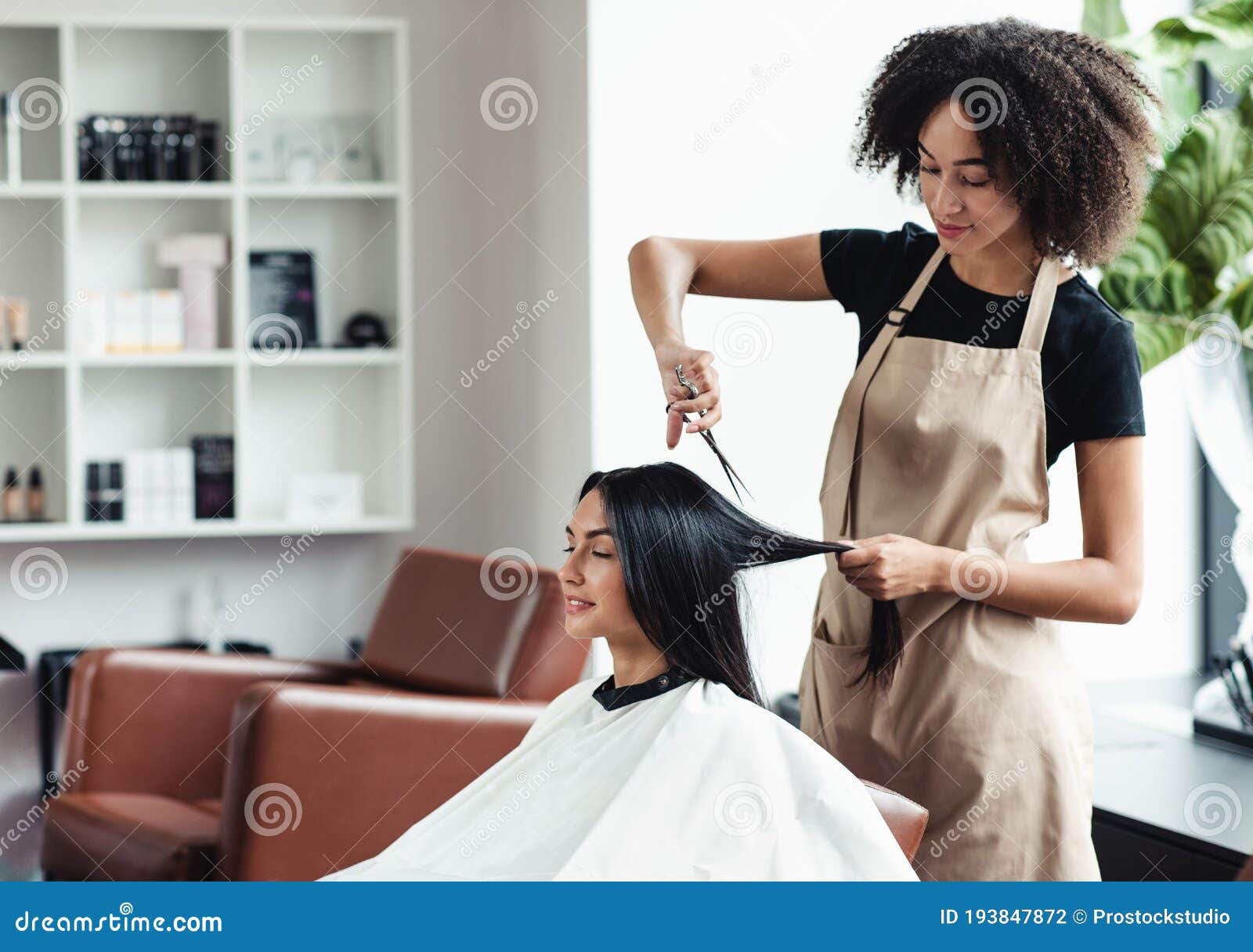 Cabeleireiro de salão de cabeleireiro faz tranças de penteado para bebê  jovem na barbearia mulher de barbeiro faz penteado elegante