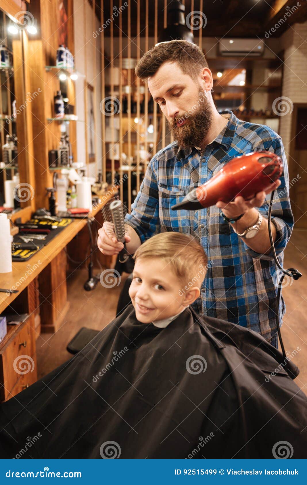 Cabeleireiro profissional bonito, segurando o secador de cabelo