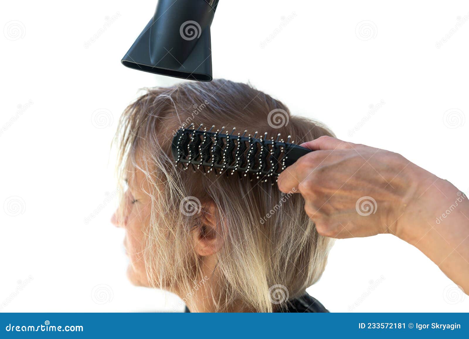 Cabeleireiro seca o cabelo com secador de cabelo para uma mulher