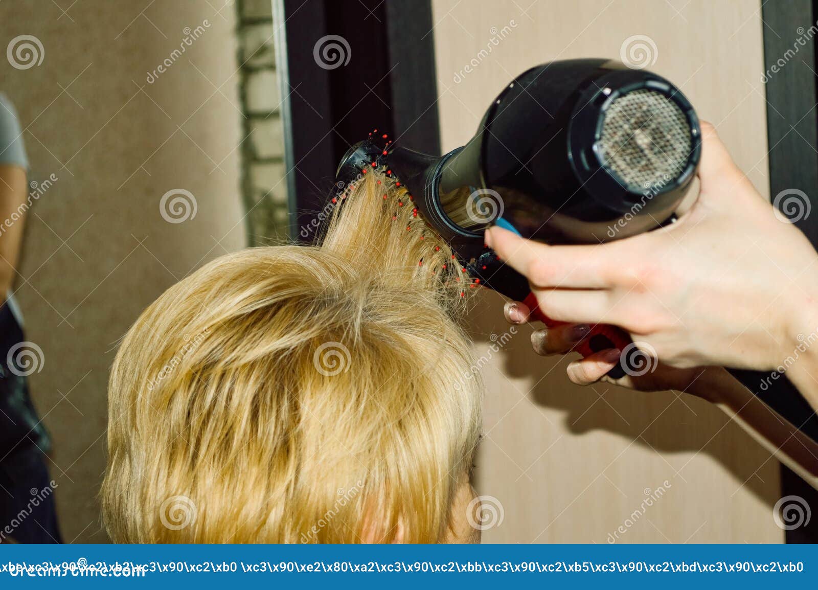 Cabeleireiro seca o cabelo com secador de cabelo para uma mulher