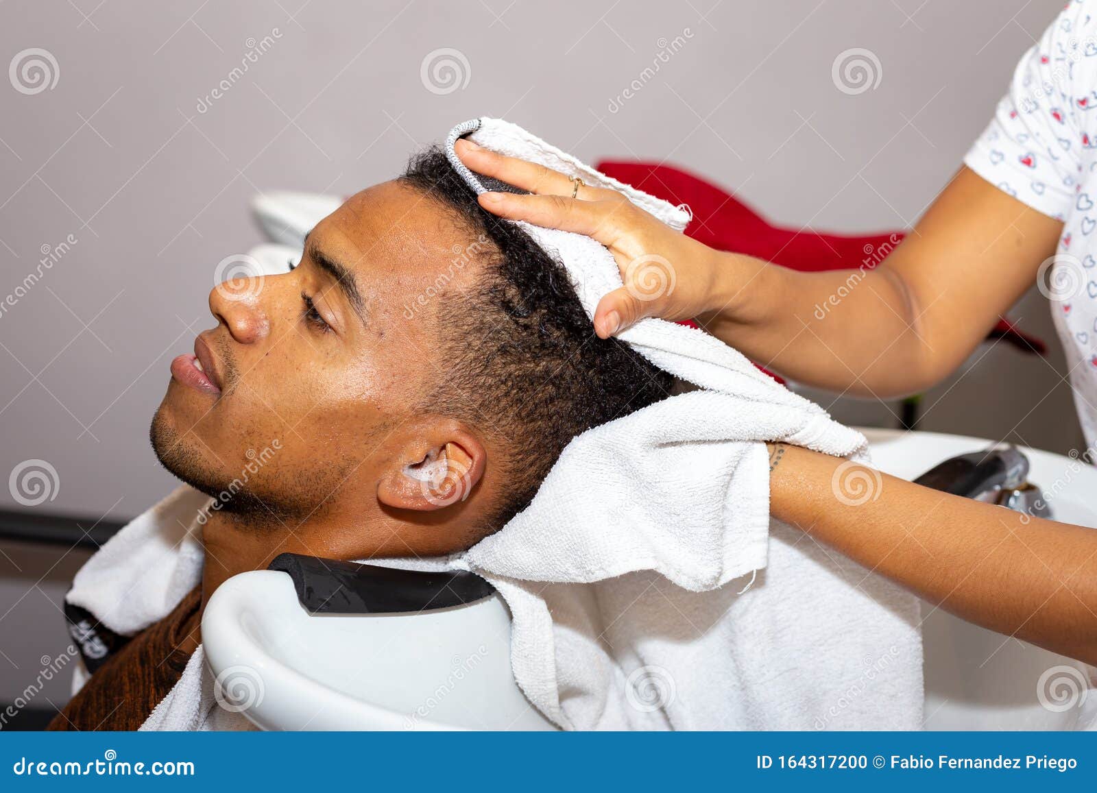 cabeleireiro secando o cabelo de seu cliente com um secador de