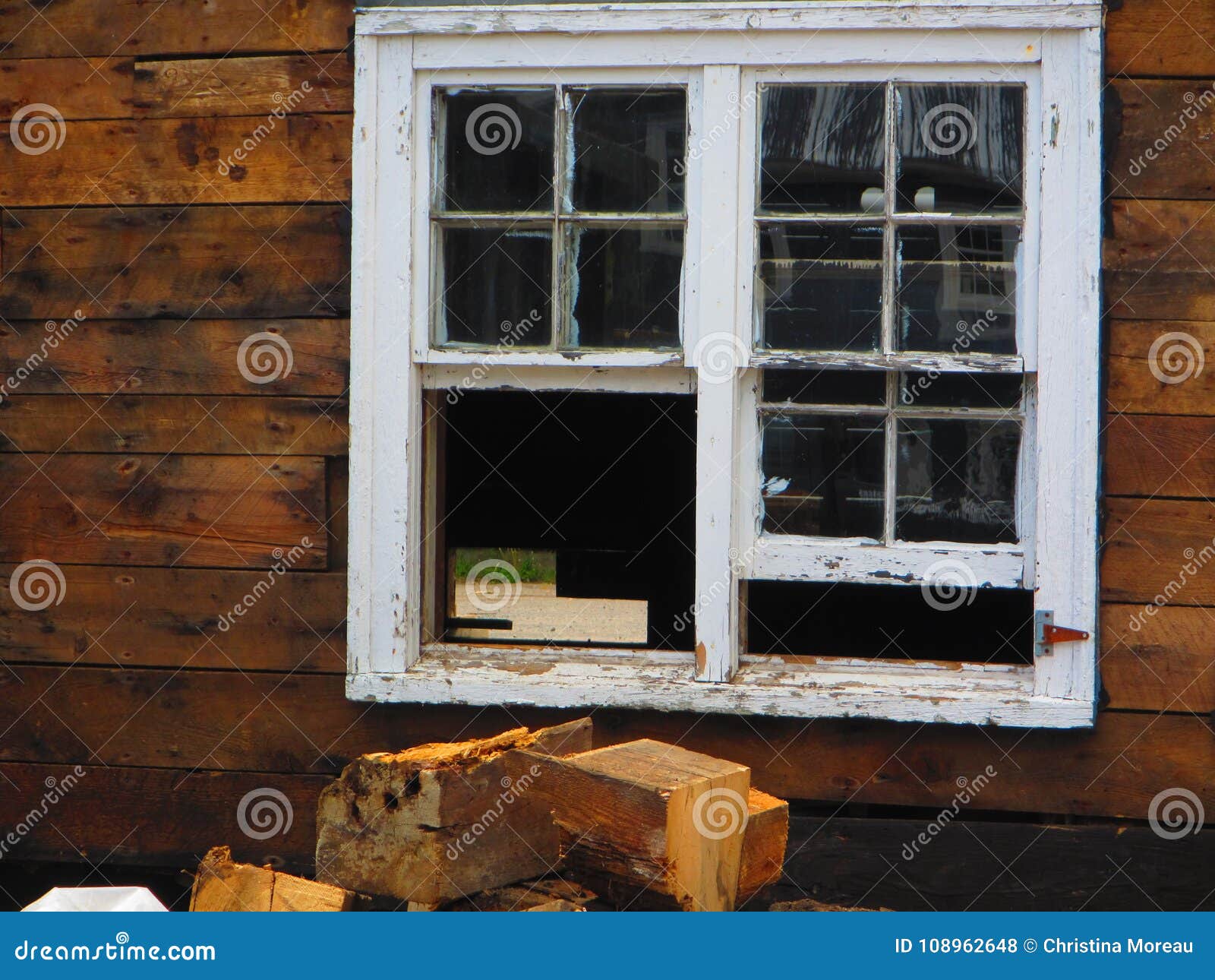 Cabina de madera rústica con la ventana. Cabina de madera rústica con una ventana con una pila de registros de madera tajados