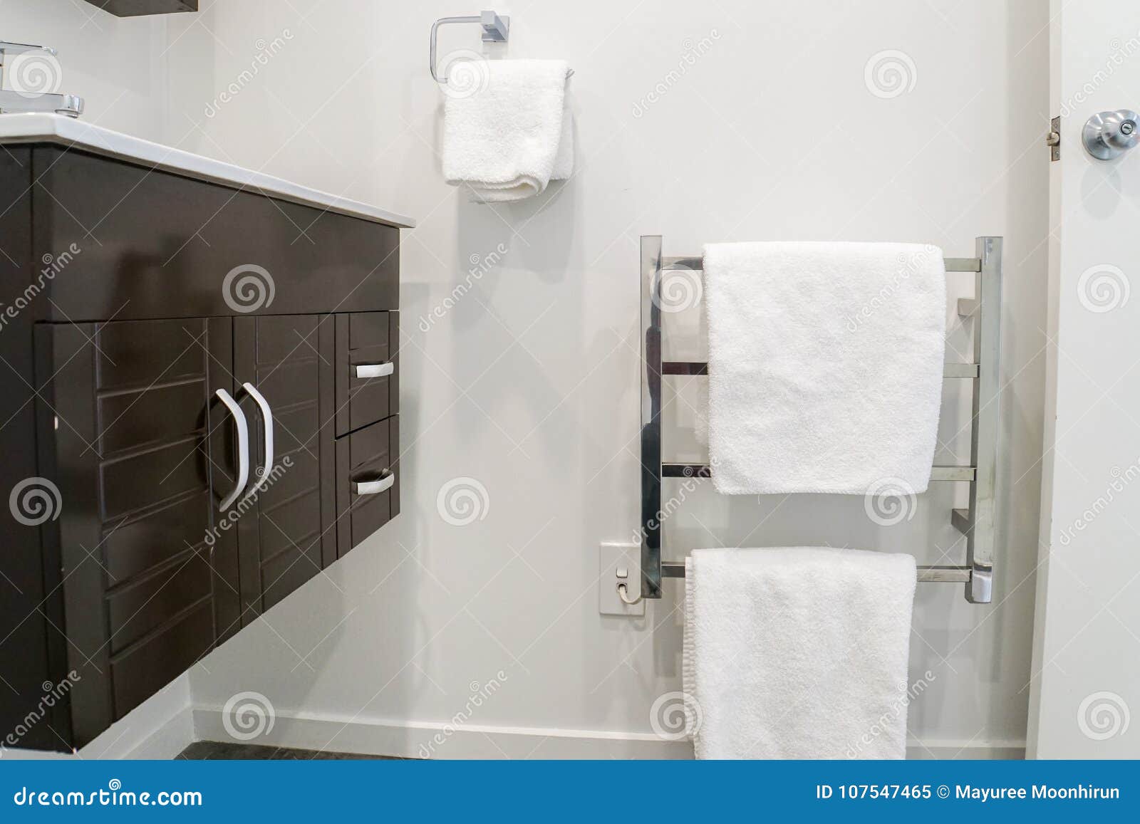 Cabinet At Basin And White Towel On Metal Rails For Taking A Bath