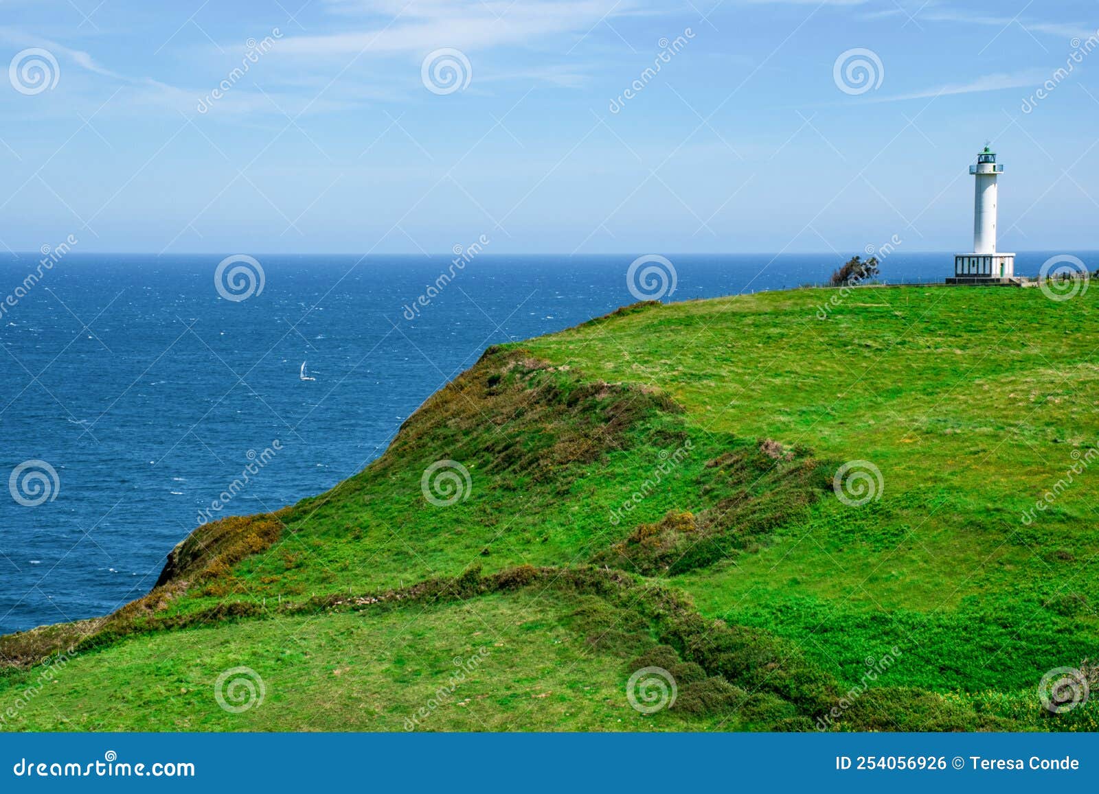 cabo de lastres lighthouse in luces-colunga, in asturias (spain), surrounded by green meadows on the cantabrian sea