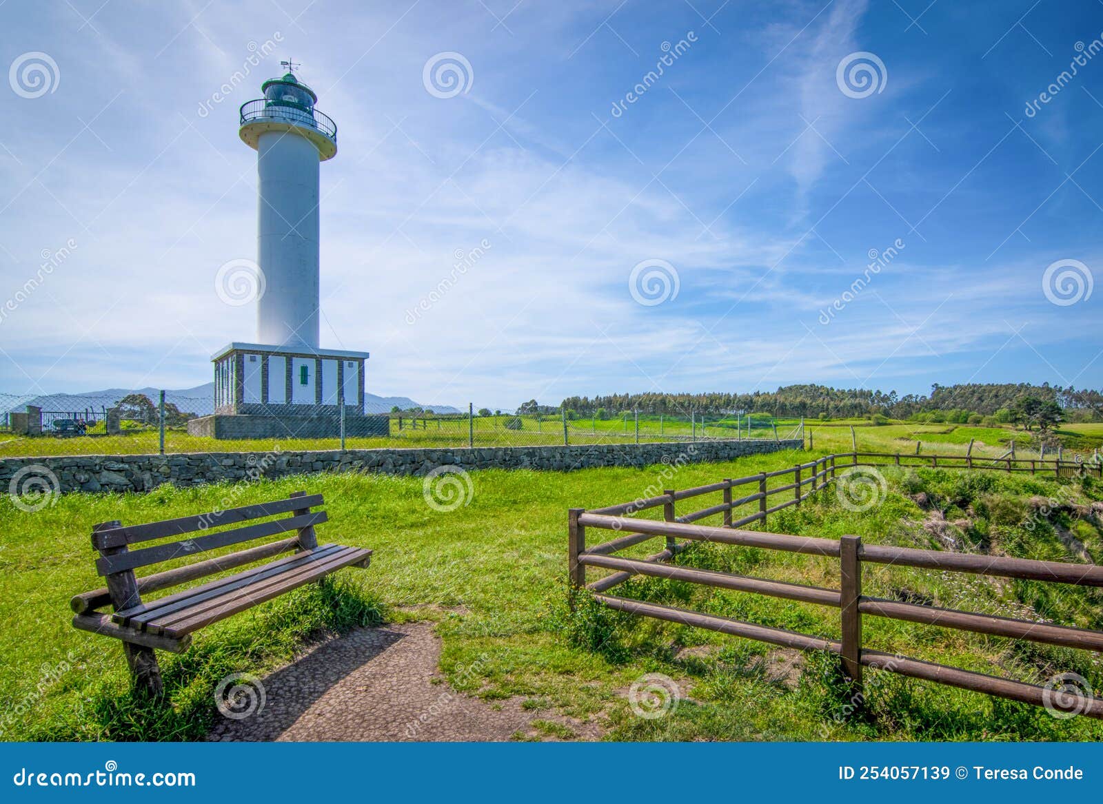 cabo de lastres lighthouse in luces-colunga, in asturias (spain), with a wooden bench in the foreground