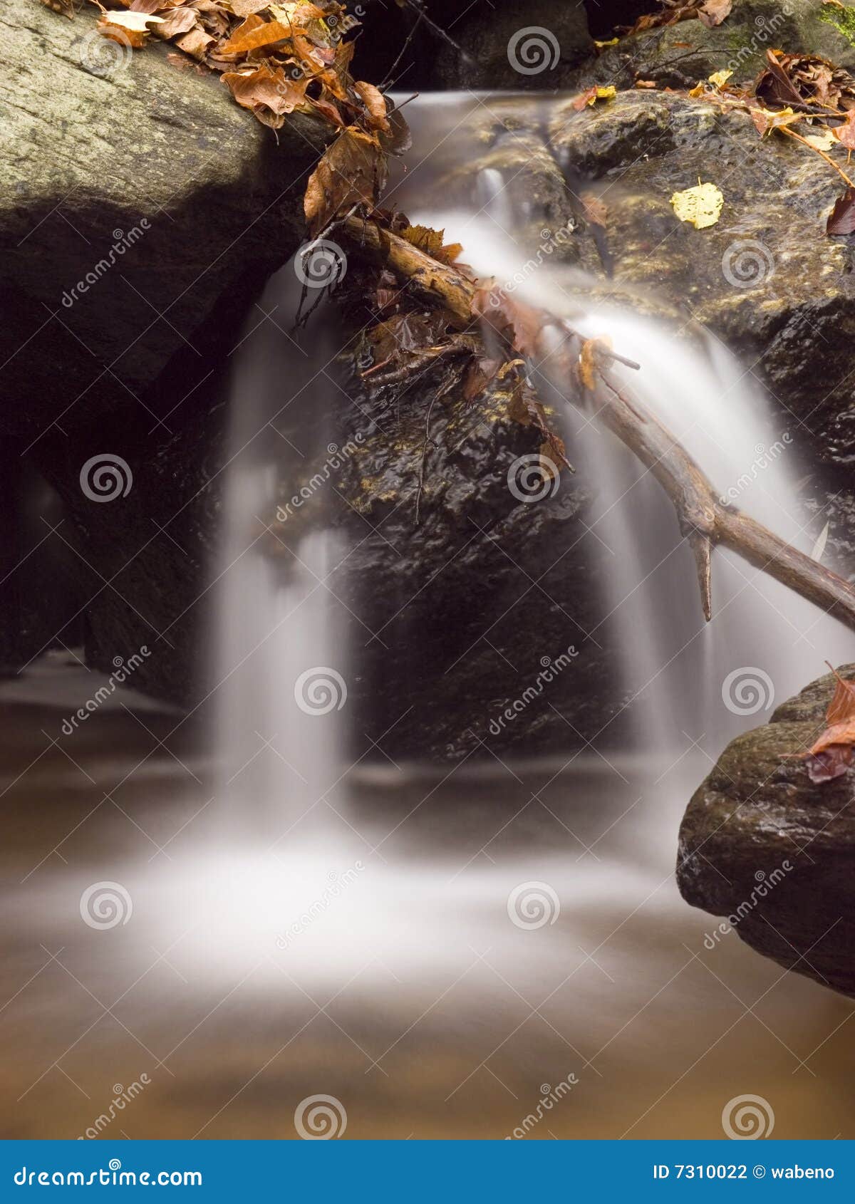 Uma cachoeira de conexão em cascata com rochas e folhas