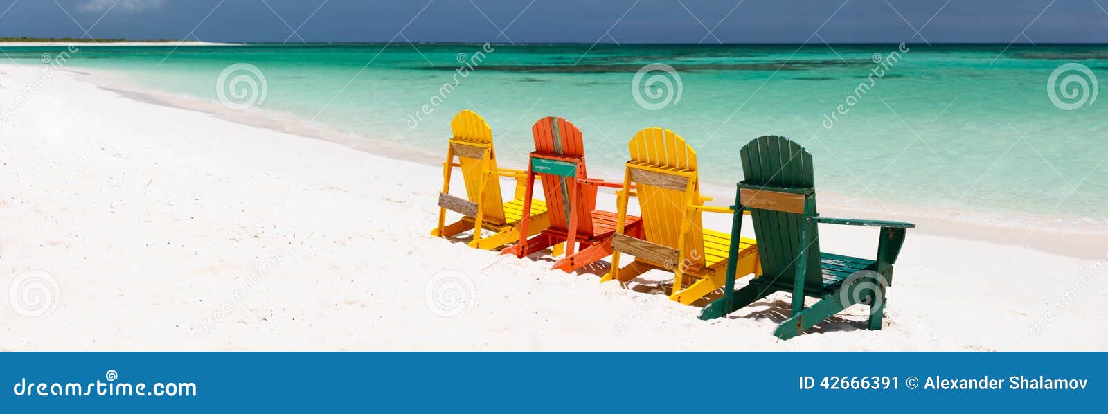 Cadeiras coloridas na praia das caraíbas. Fileira de cadeiras de madeira coloridas na praia branca tropical da areia nas Caraíbas, panorama com o espaço da cópia perfeito para bandeiras