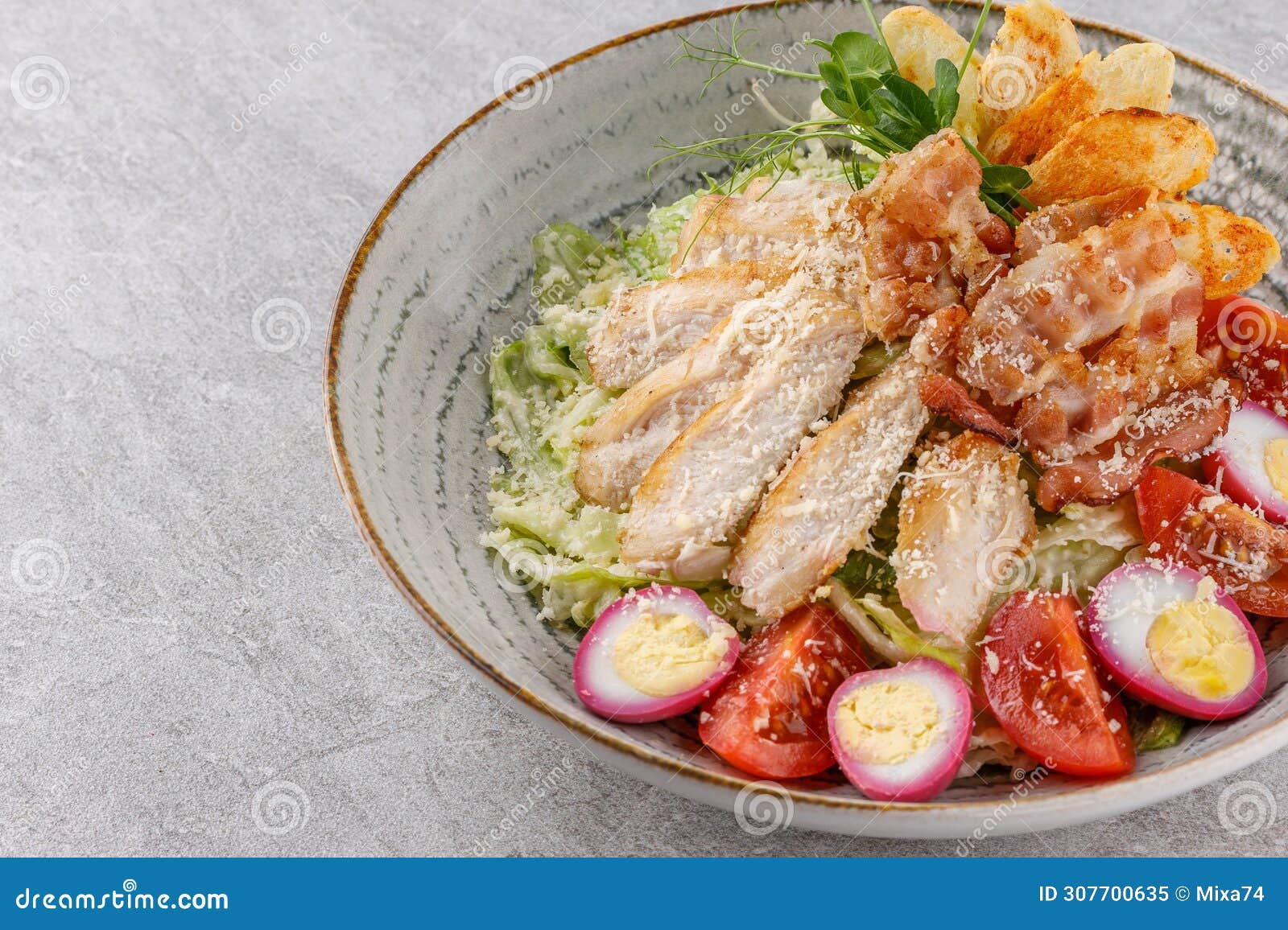 caesar salad with chicken and bacon on a stone background studio food photo6