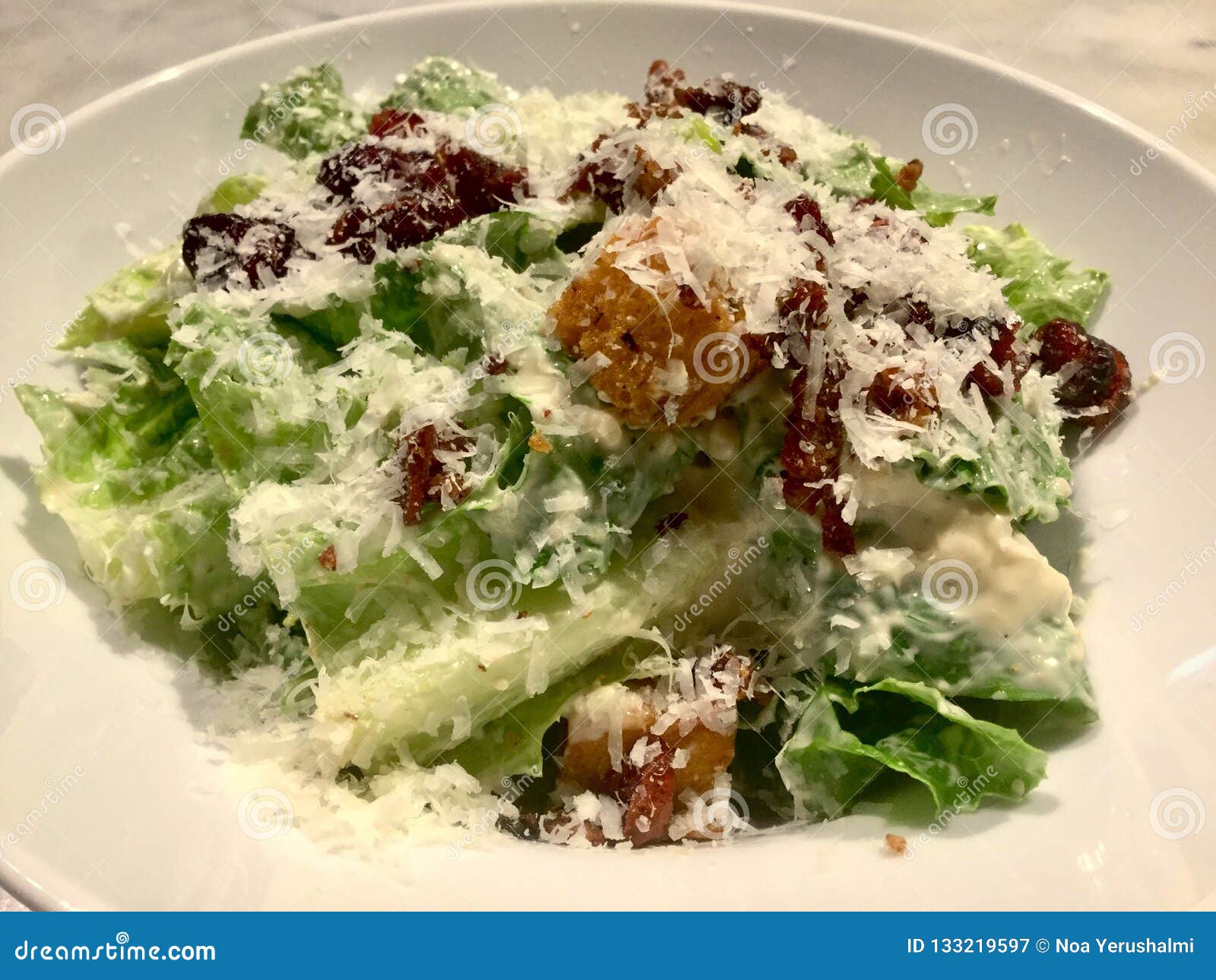 Caesar Salad feinschmecker Frischer Salatteller Abschluss oben. Ein Caesar-Salat ist ein grüner Salat des Römersalats und der Croutons, die mit Zitronensaft, Olivenöl, Ei, Worcestersoße, Knoblauch, Parmesankäseparmesankäse und schwarzem Pfeffer zurechtgemacht werden In seiner Ausgangsmaske wurde dieser Salat und gedientes tableside zugebereitet Viele Veränderungen dieses Salats existieren; Jogurt wird manchmal ersetzt, damit die Eier eine sahnige Beschaffenheit beibehalten und andere fordern die Anwendung der Majonäse Ein Salat ist ein Teller, welche aus einer Mischung von Stückchen Lebensmittel, normalerweise Gemüse besteht Jedoch enthält möglicherweise unterschiedliche Vielzahl des Salats praktisch irgendeine Art essfertiges Lebensmittel