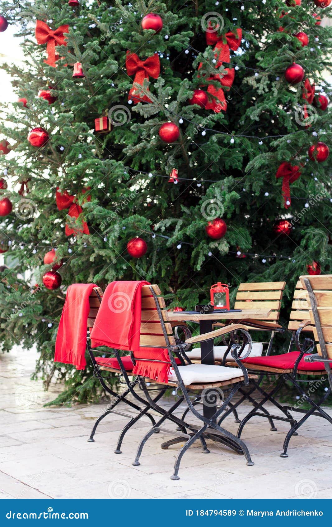 CafÃ© Callejero Bajo Un Ã¡rbol De Navidad Con Adornos Rojos Al Aire Libre.  Mesas Y Sillas De Madera Imagen de archivo - Imagen de sillas, europeo:  184794589