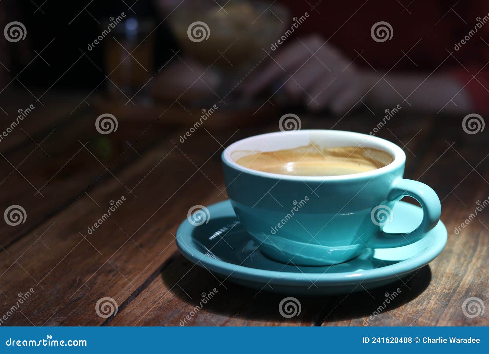 hot black coffee in blue ceramic cup on wooden table background.