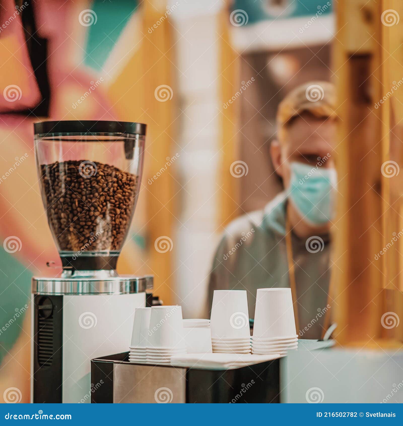 Cafetera Con Granos De Café Y Filas De Tazas De Papel Boca Abajo Para Café  Fondo Borroso Del Vendedor Foto de archivo - Imagen de servicio, filas:  216502782