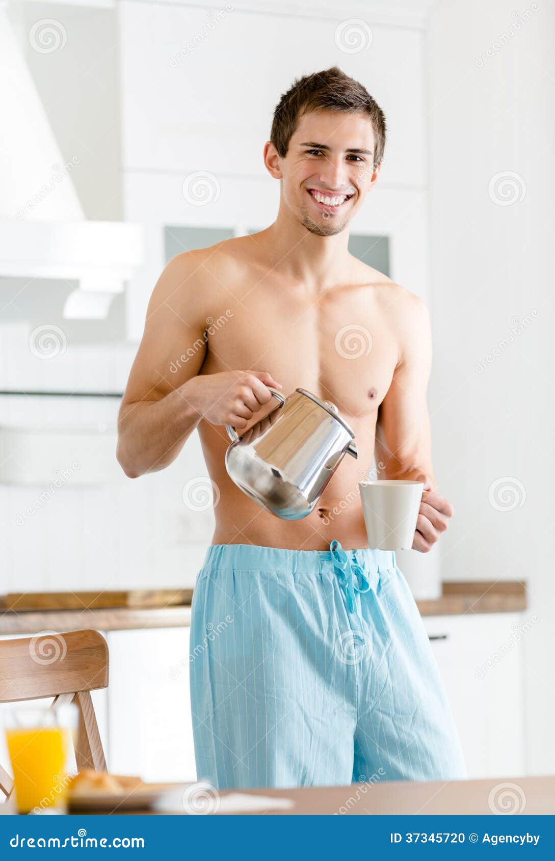 Café se renversant d'homme à moitié nu à la cuisine, prenant le petit déjeuner