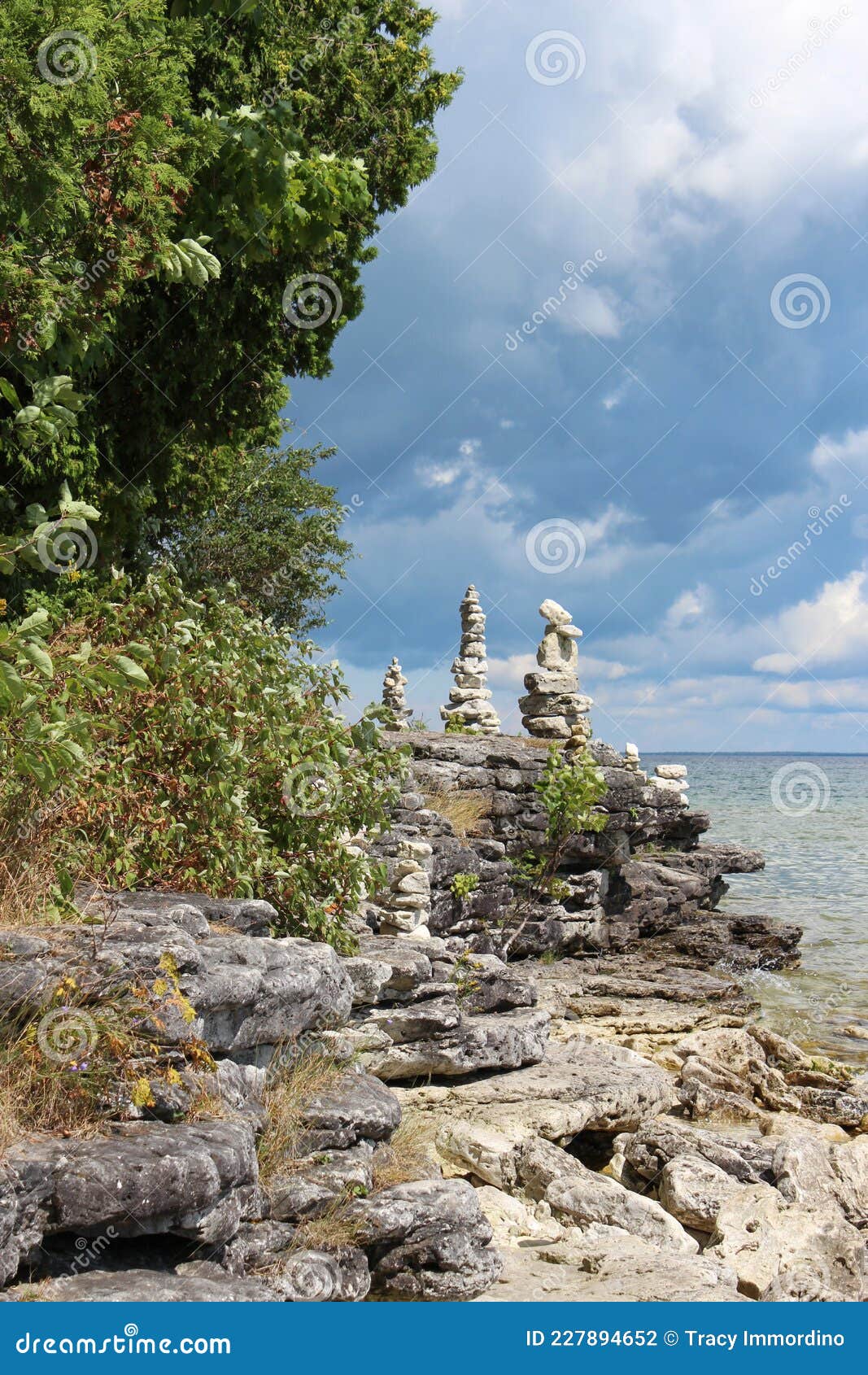 cairns stacked on the rocky shoreline of lake michigan in cave point county park, door county, wisconsin