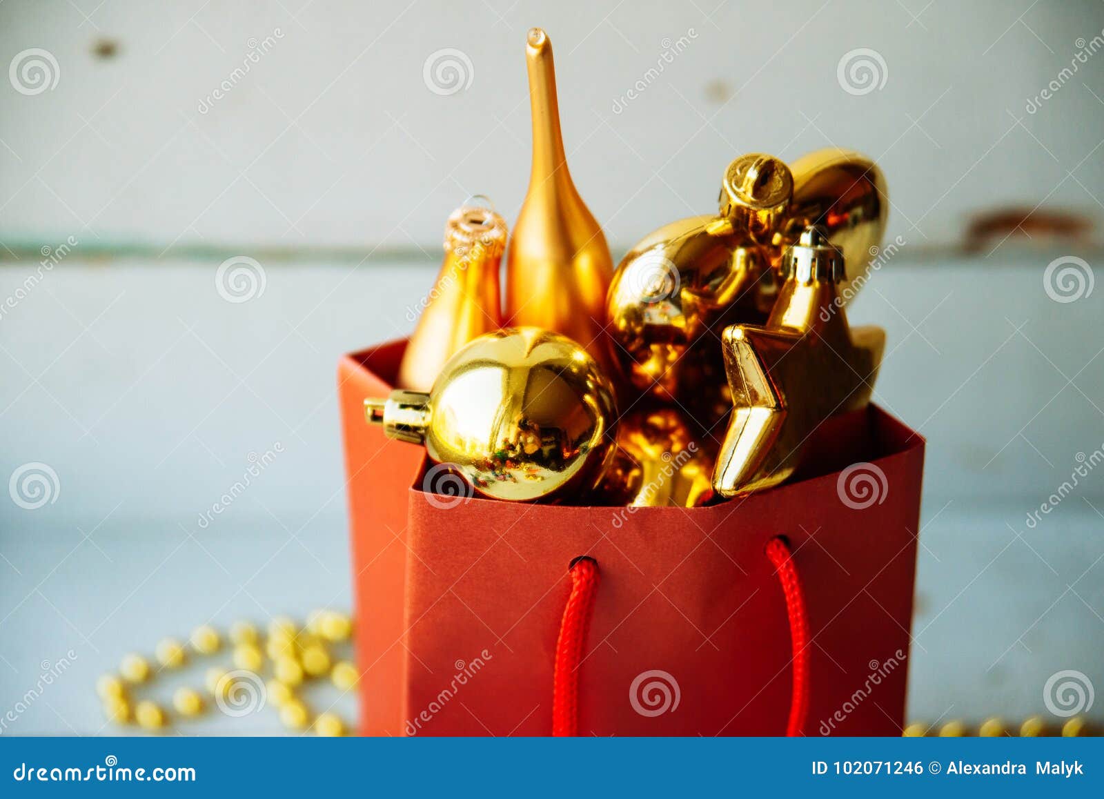 Caja de regalo adornada debajo del árbol de navidad. Fondo de la Navidad, tarjeta de felicitación, paisaje Caja roja con los corazones, las estrellas y las guirnaldas del oro de las decoraciones del árbol de navidad