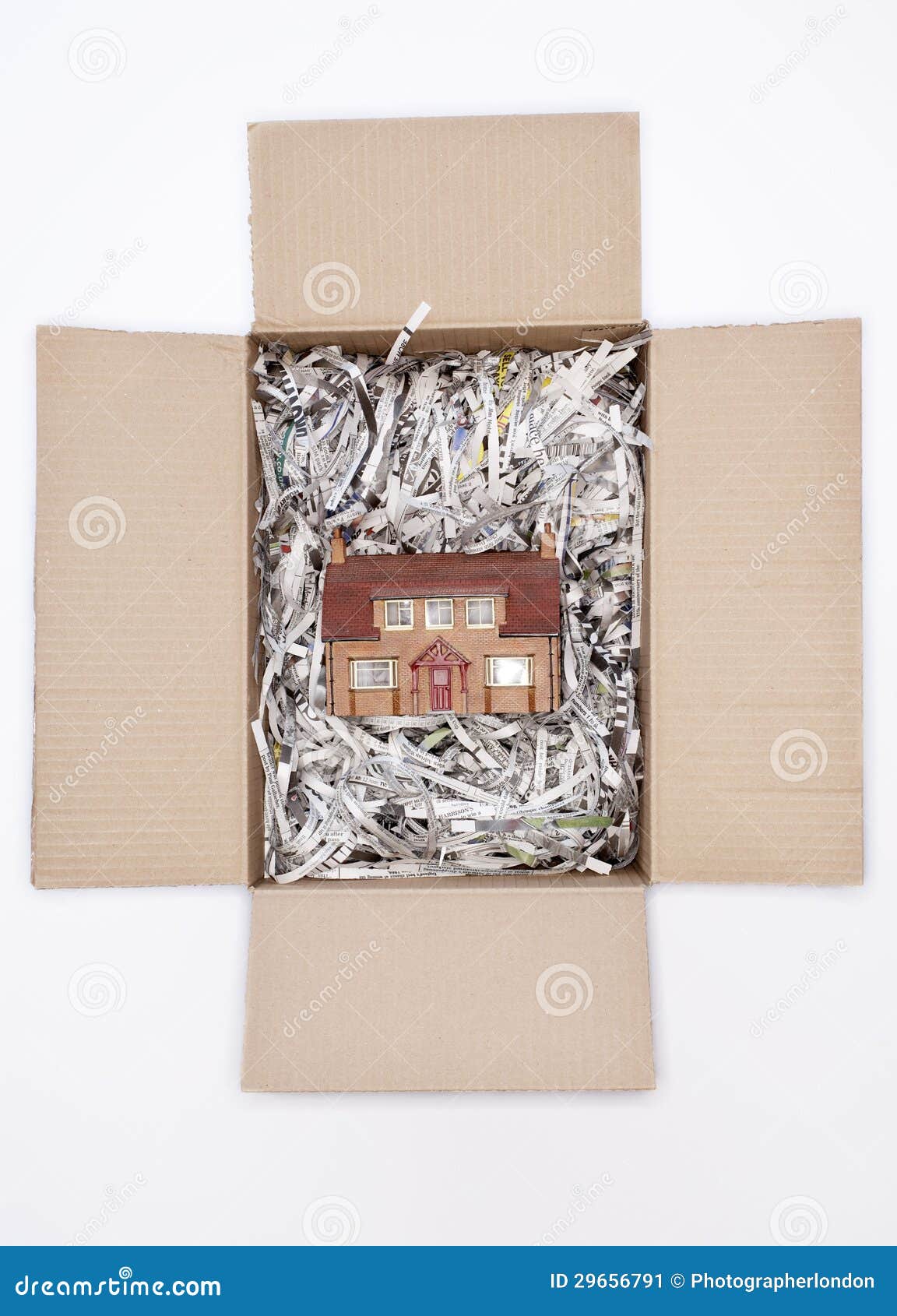 Caja modelo de House In Cardboard. Casa modelo en caja de cartón con el documento destrozado sobre el fondo blanco