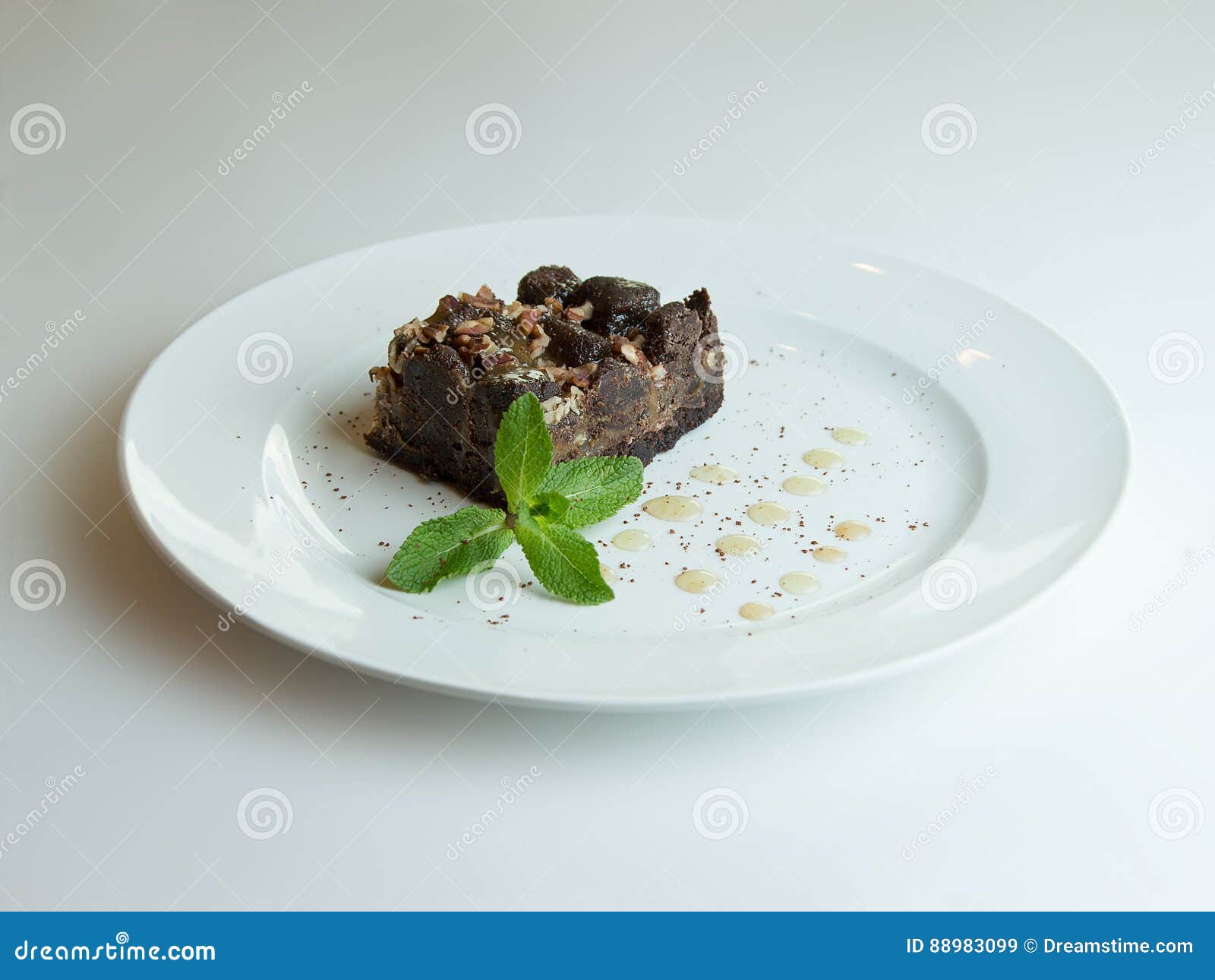 Cake chocolate brownies on wooden background. Chocolate brownie, sugar syrup and mint sprig