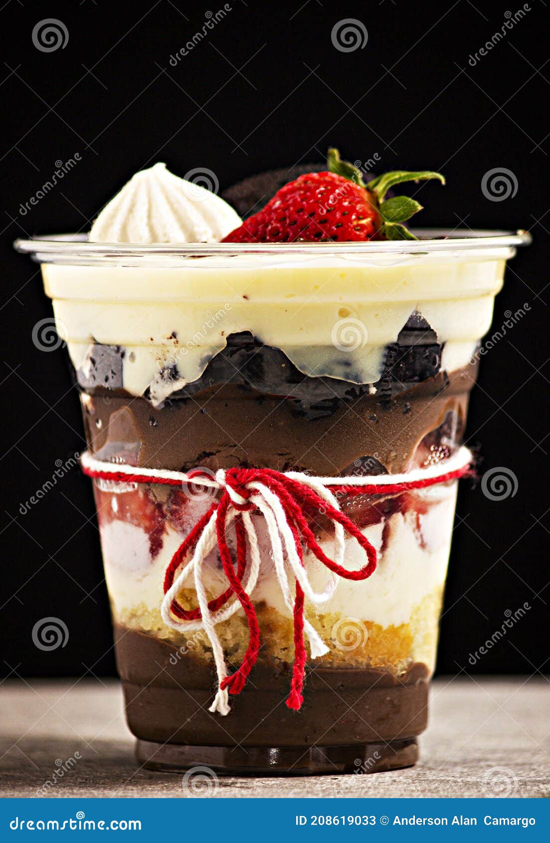 cake pot with strawberry and meringue on black background, brazilian copo da felicidade