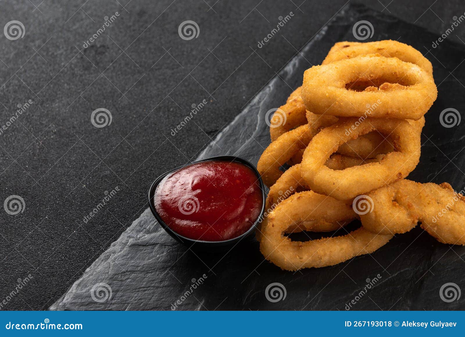 Calamari Rings Deep-fried in Breading. Crispy Squid Rings on a Dark