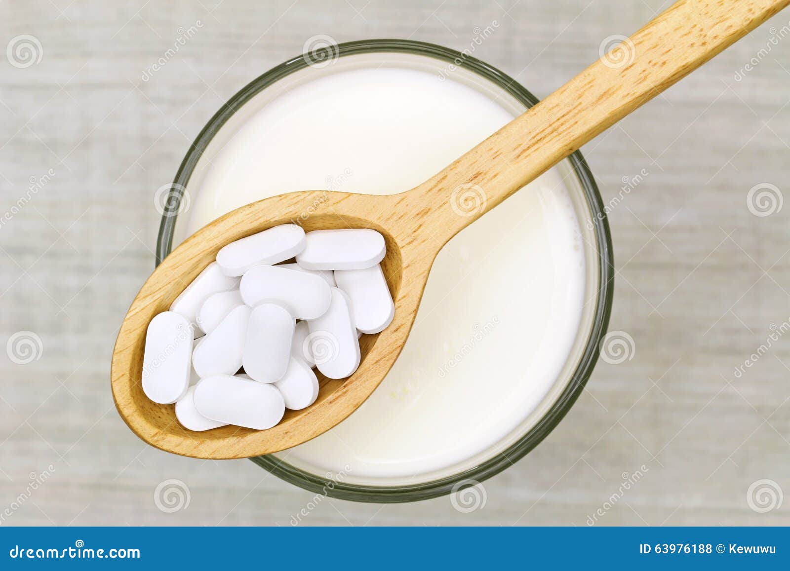 calcium carbonate tablets above a glass of fresh milk