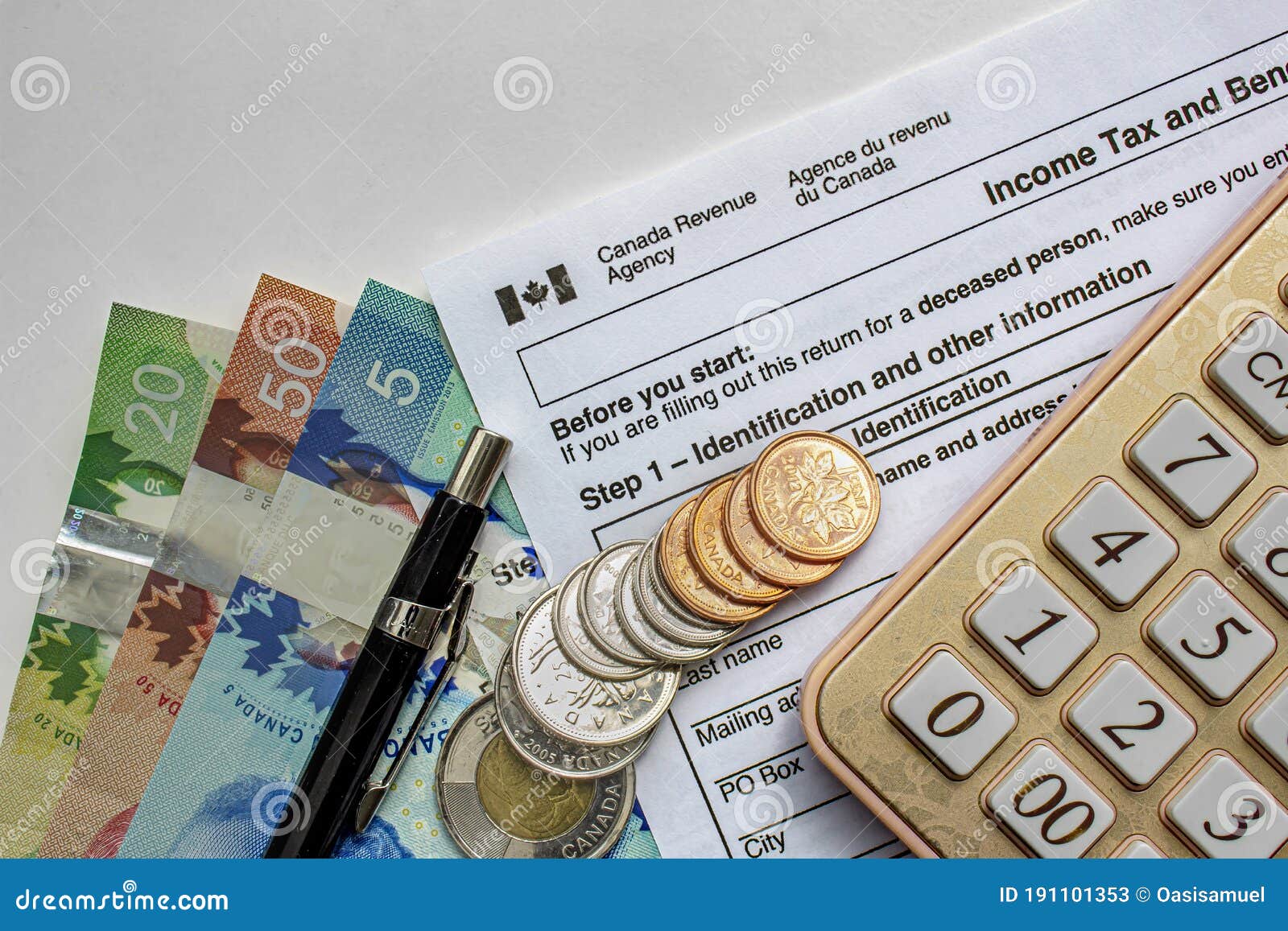 Canadian Tax Forms with Coins, Calculator, a Pen and Bills on a White