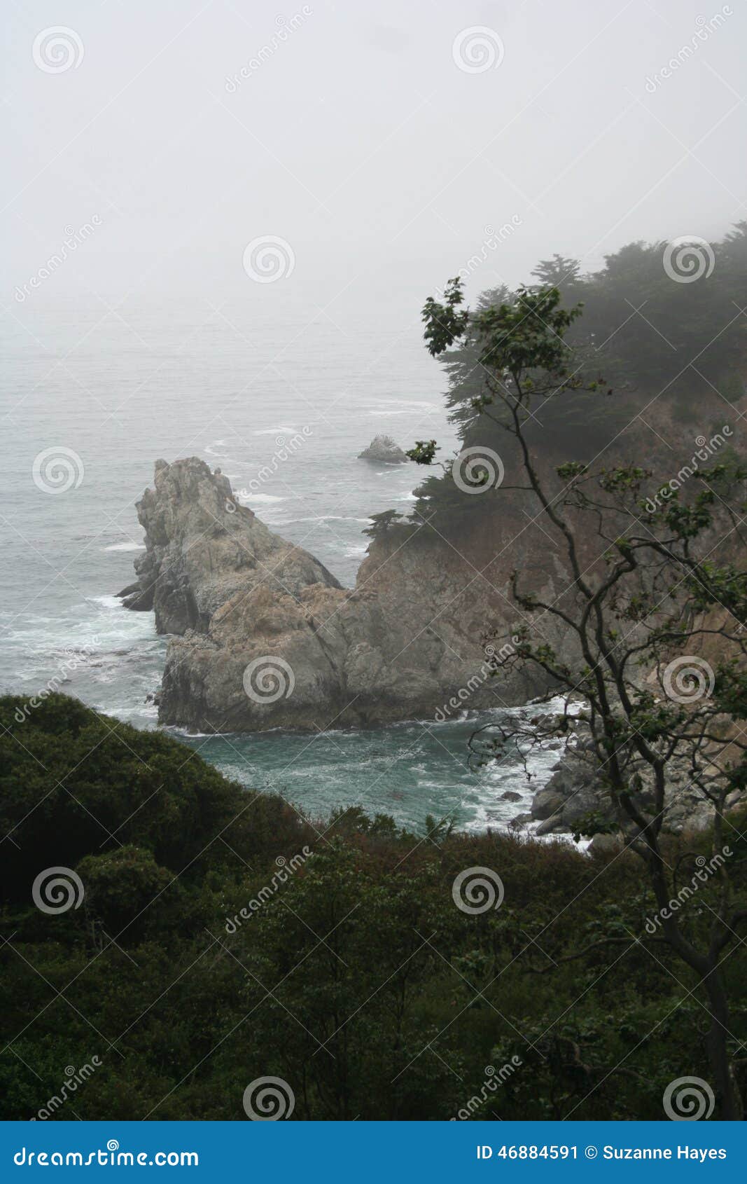 Califórnia Rocky Coast com vertical da ressaca. Califórnia Rocky Coast com penhascos e ressaca e névoa, tiro vertical