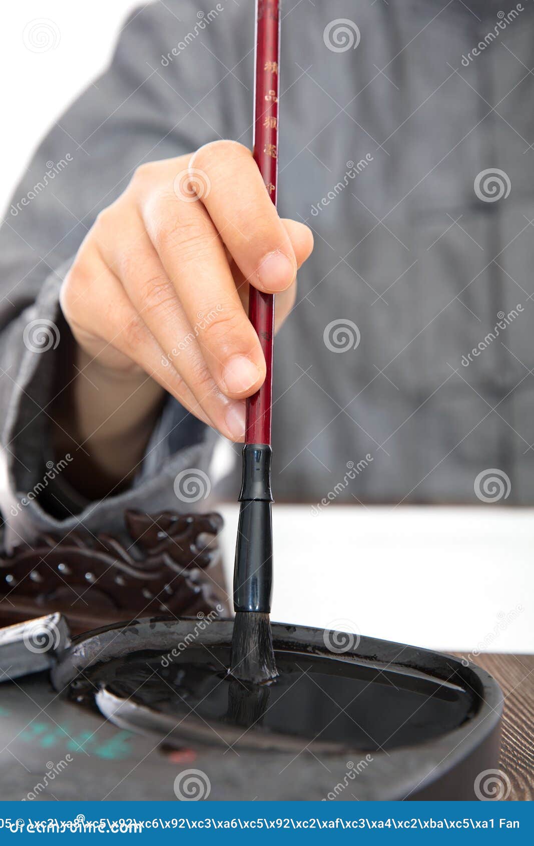 The Calligrapher Sticks Ink in the Inkstone with a Brush in His Hand