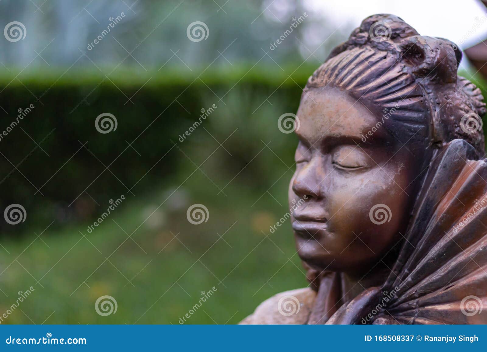 calm face of a woman statue in a graden. buddhism and peace concept