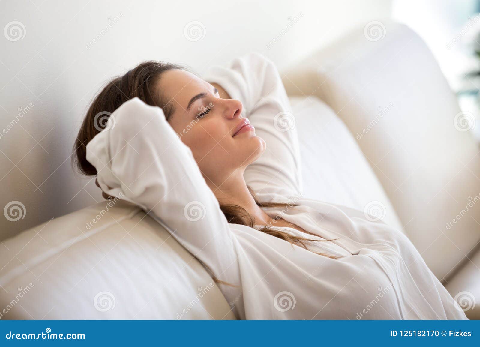 calm millennial woman relaxing on comfortable sofa breathing fre