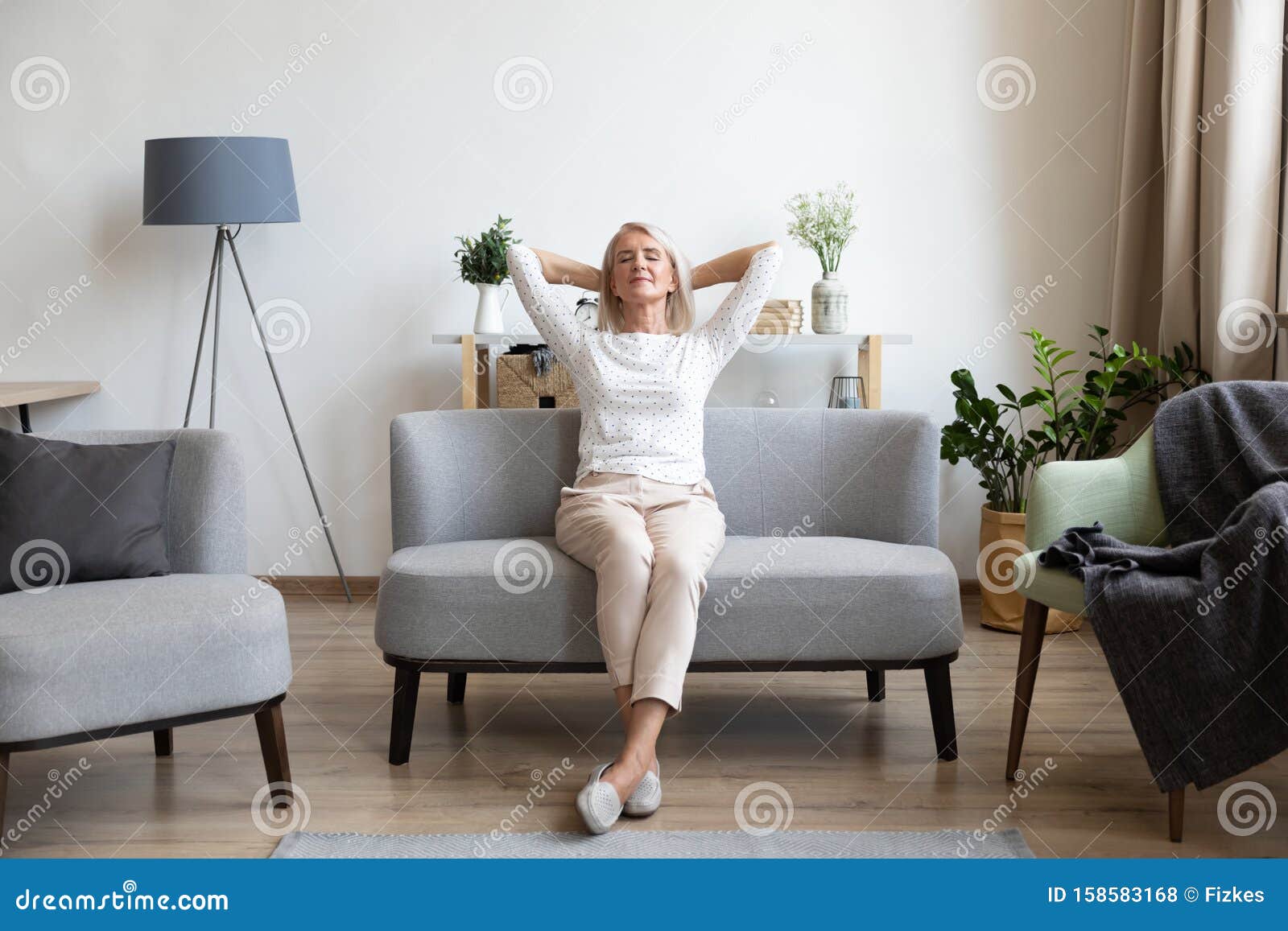 Calm Older Mature Woman Relaxing On Comfortable Sofa At Home Stock