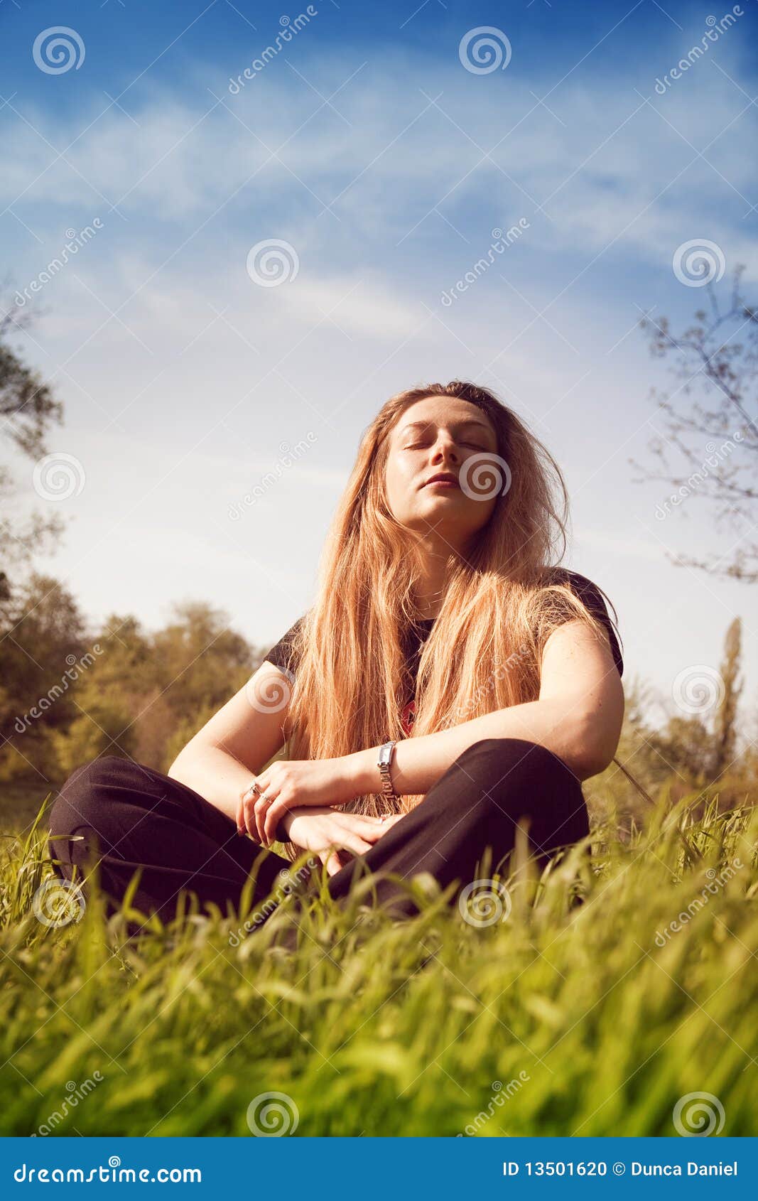 calm woman relaxing in sunny grass field
