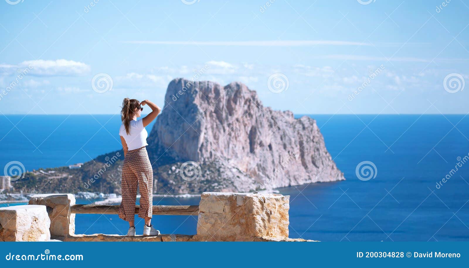 calpe coast, tourist woman looking at calpe or calp coast and penon the ifach or penyal d`ifac natural park from path