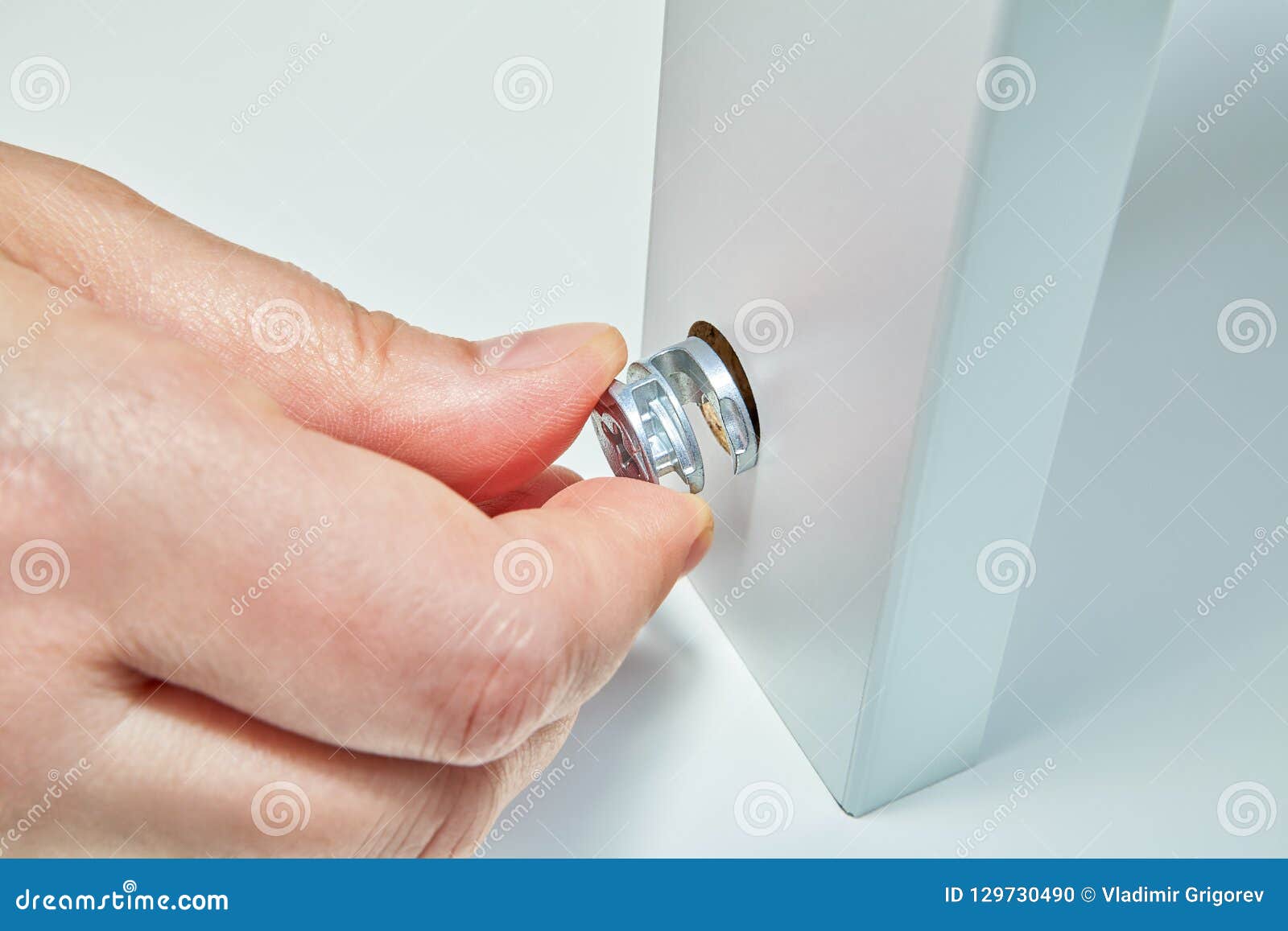 Cam Lock Nut In Hand Of Flat Pack Furniture Assembler Stock Photo