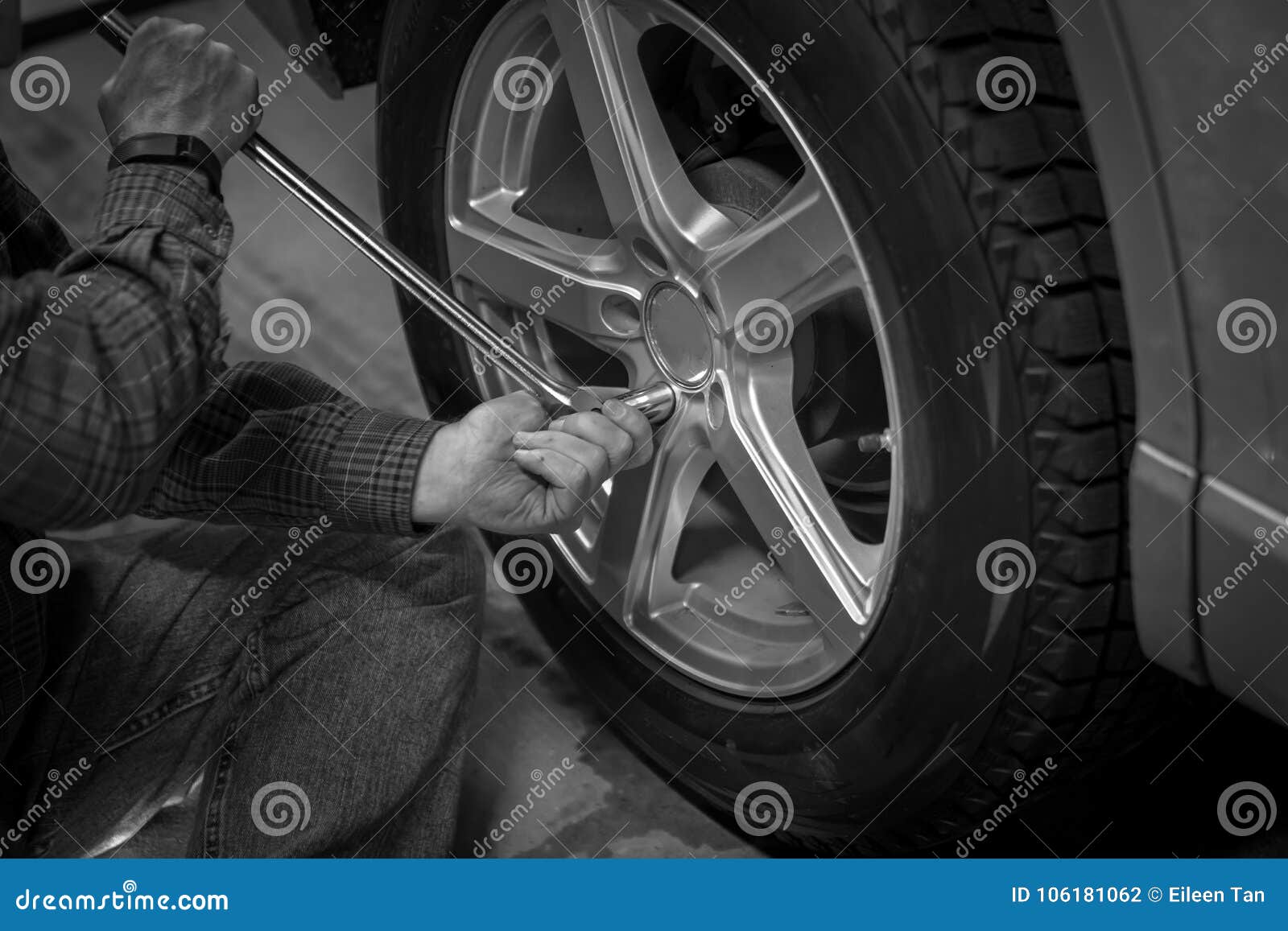 Cambi e ripari la ruota di automobile. Equipaggi la ruota di automobile cambiante e di riparazione con la chiave lunga a disposizione