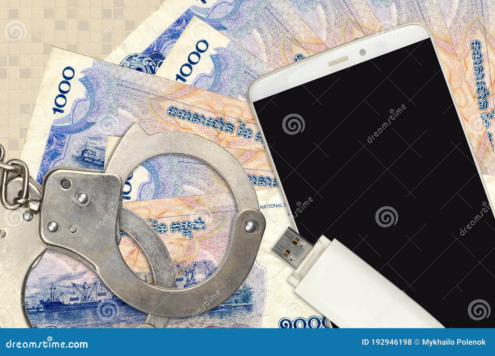 1000 cambodian riels bills and smartphone with police handcuffs. concept of hackers phishing attacks, illegal scam or malware soft