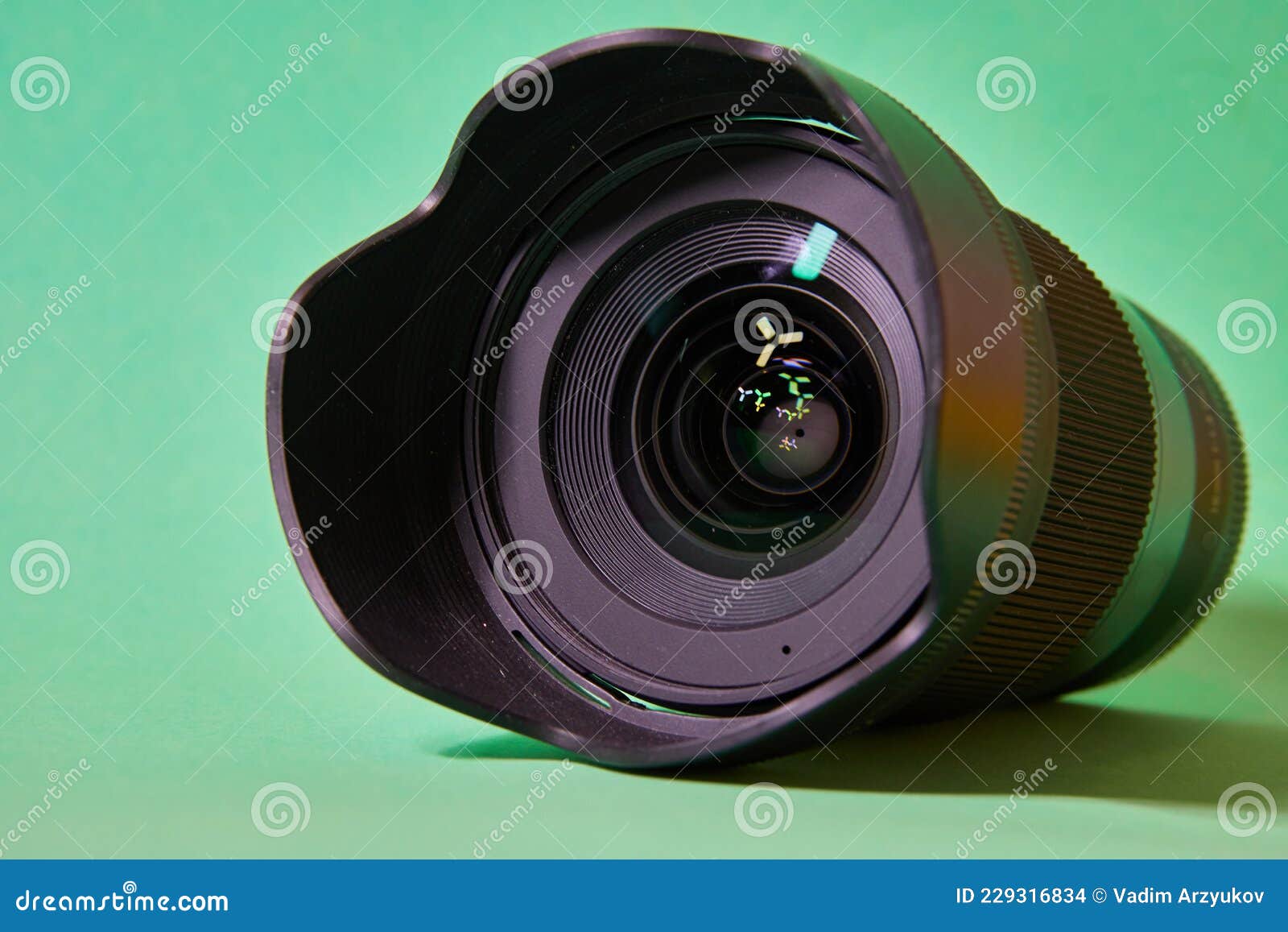 camera lens with glare on the front lens on a green background