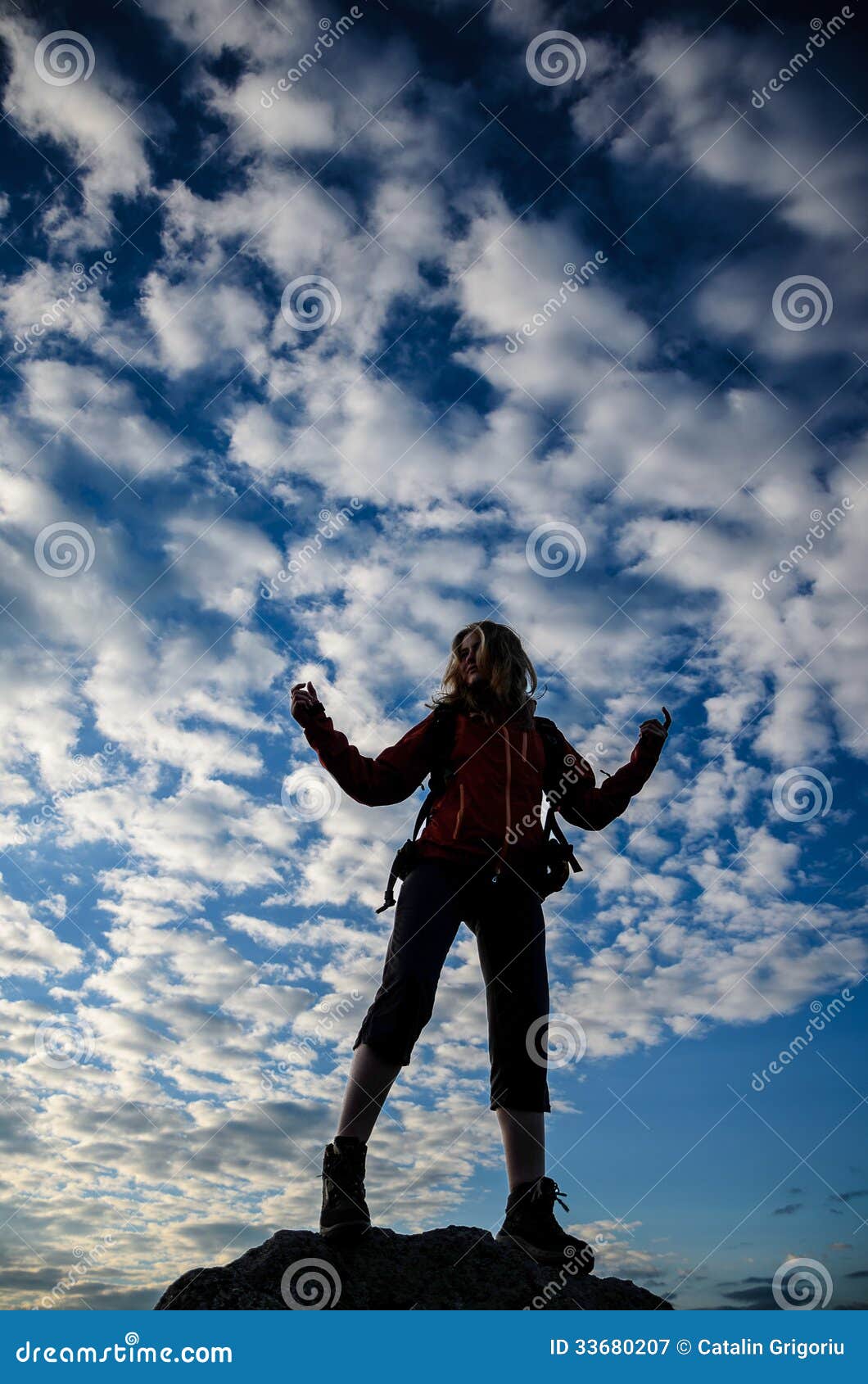 Caminante en meditar la posición. El caminante de la muchacha se está colocando con sus brazos aumentados en una posición que medita respecto a la cumbre de una montaña en la salida del sol