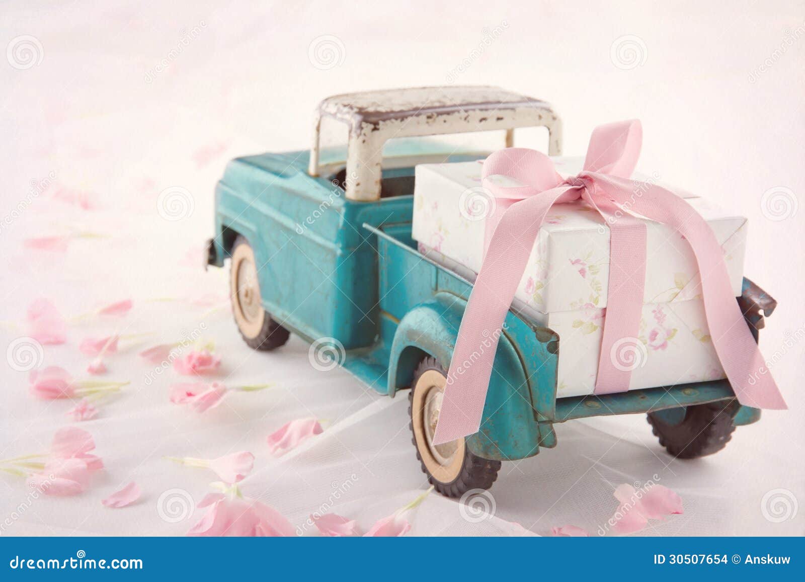 Um caminhão de brinquedo rosa com uma caixa de madeira