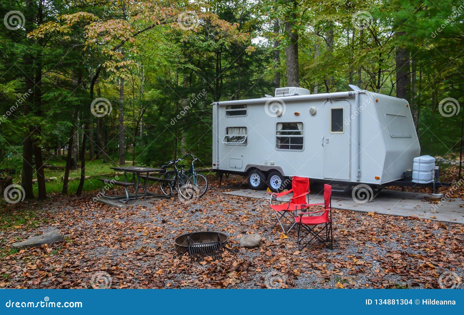 Camp Trailer Set Up In Campground Site With Bicycles Stock Photo