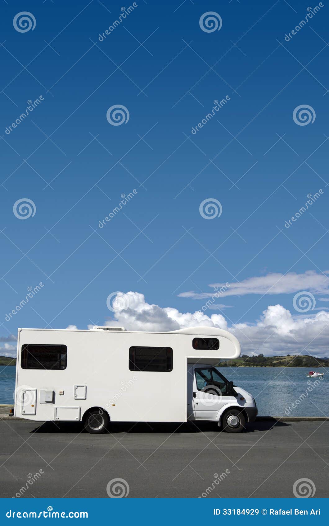 Camper on a road trip. White campervan parked on a lake during road trip around New Zealand.