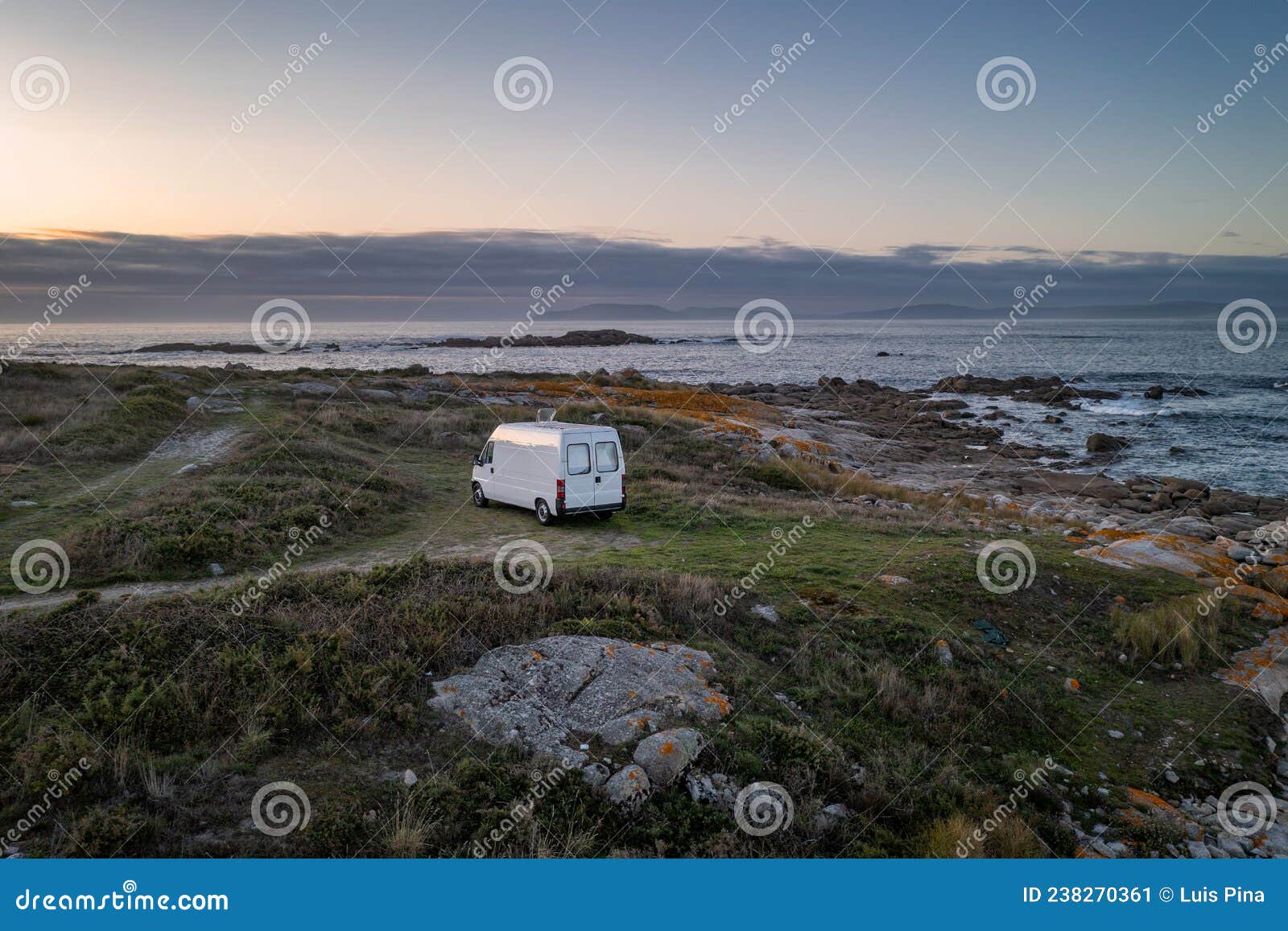 camper van motorhome with solar panels drone aerial view on a sea landscape with mountains living van life in galiza, spain