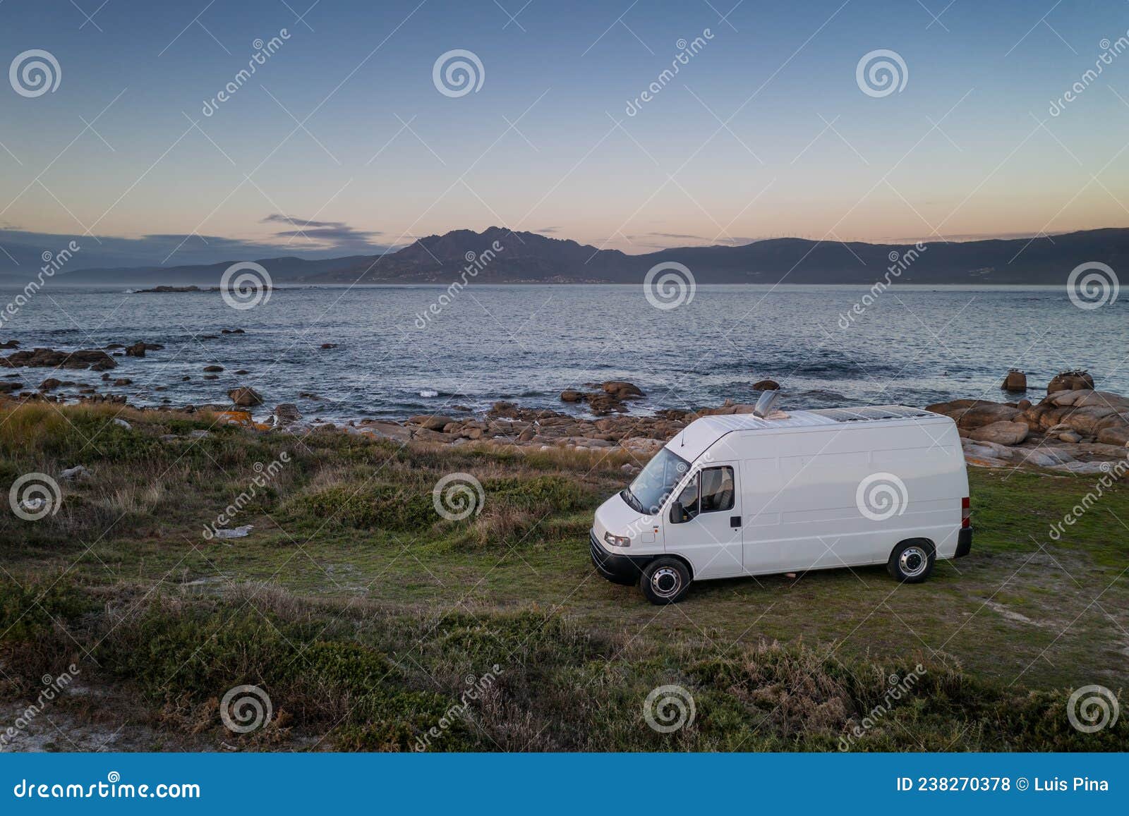 camper van motorhome with solar panels drone aerial view on a sea landscape with mountains living van life in galiza, spain
