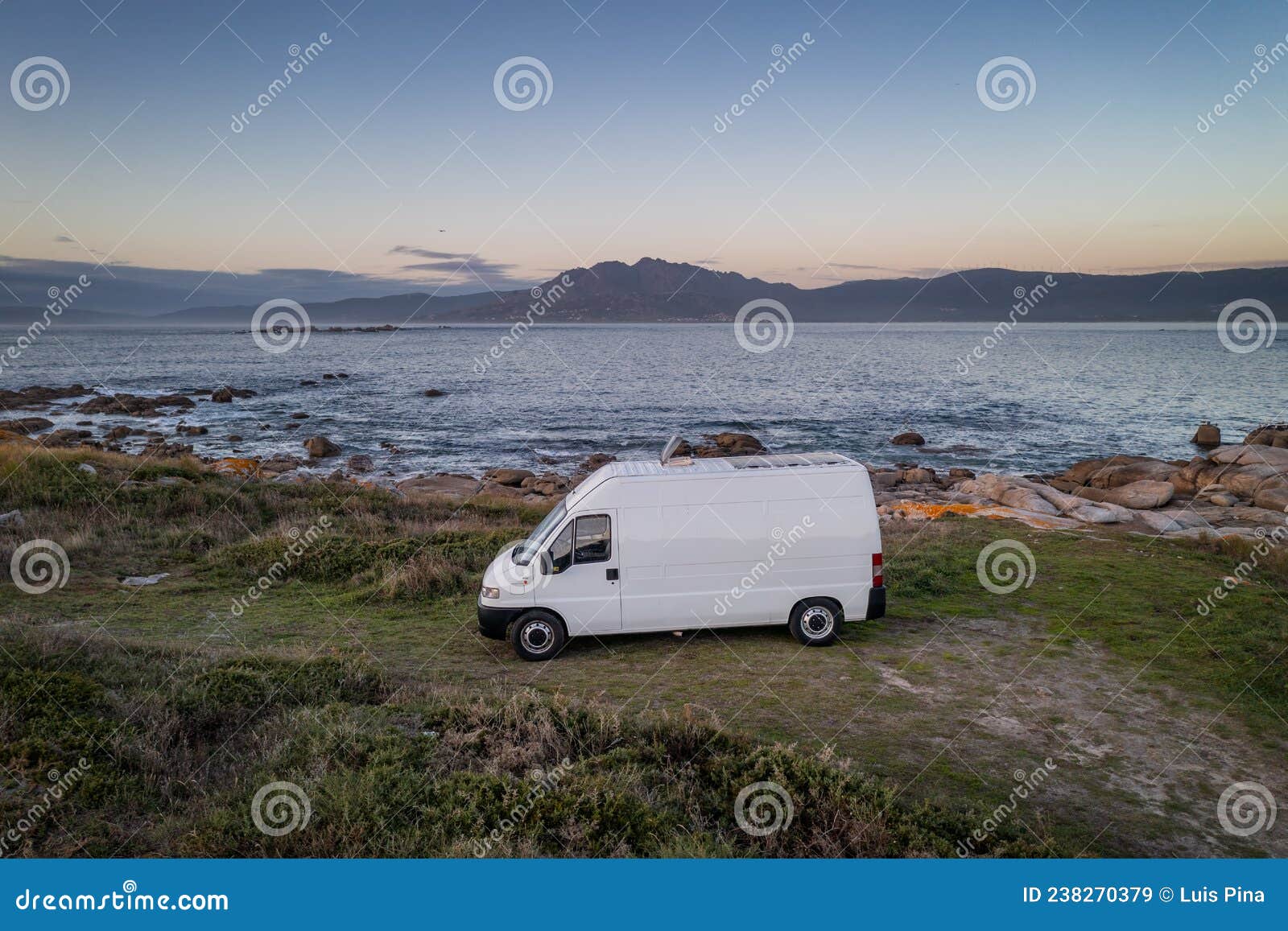 camper van motorhome with solar panels drone aerial view on a sea landscape with mountains living van life in galiza, spain