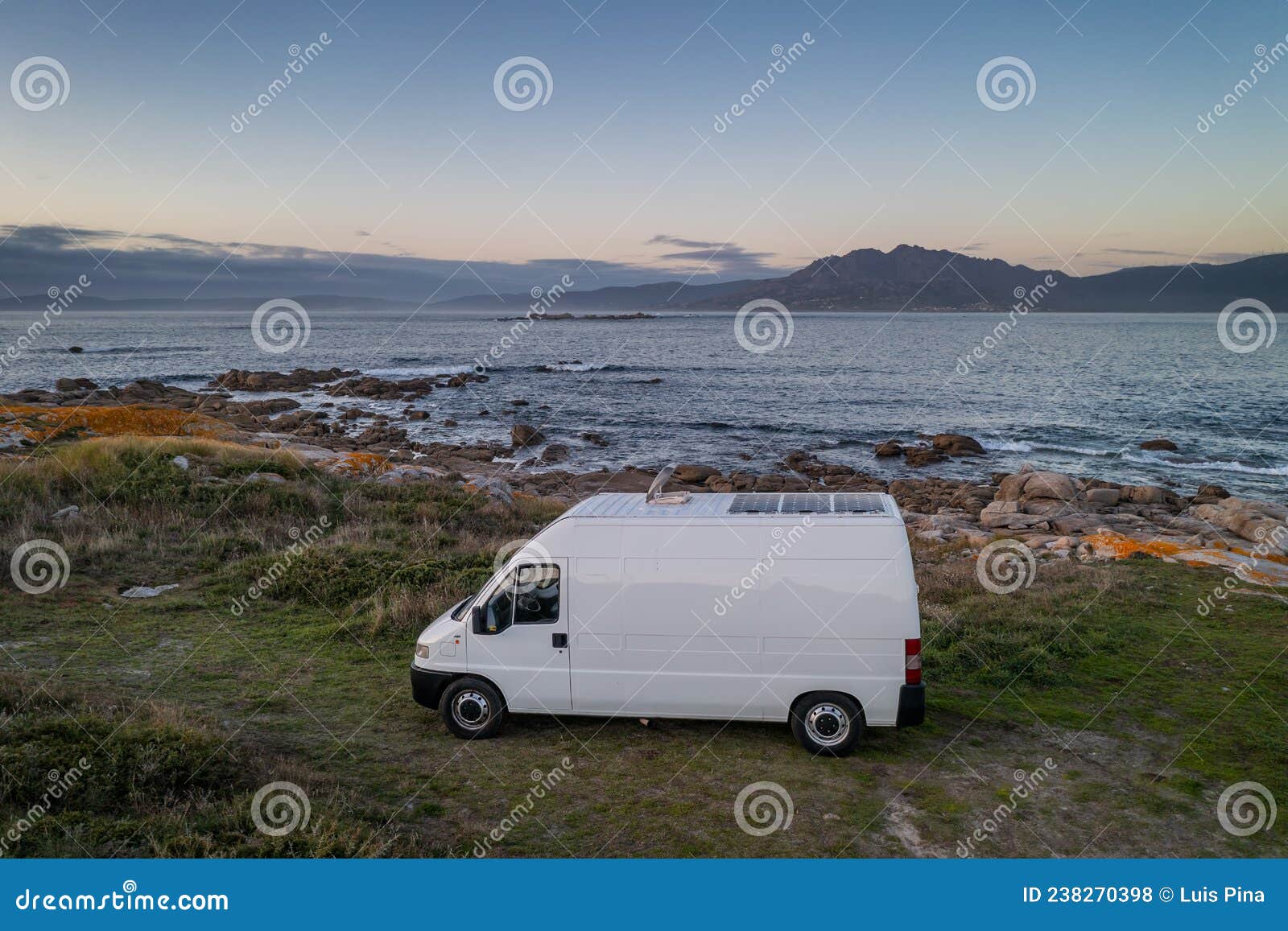 camper van motorhome with solar panels drone aerial view on a sea landscape with mountains living van life in galiza, spain