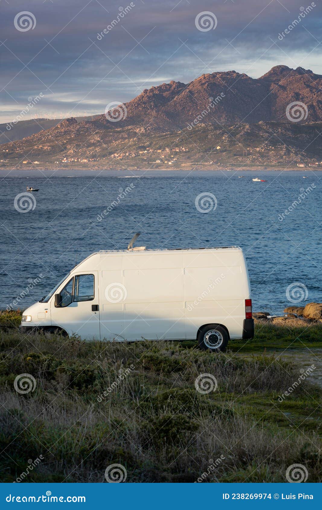 camper van motorhome with solar panels view on a sea landscape with mountains living van life in galiza, spain