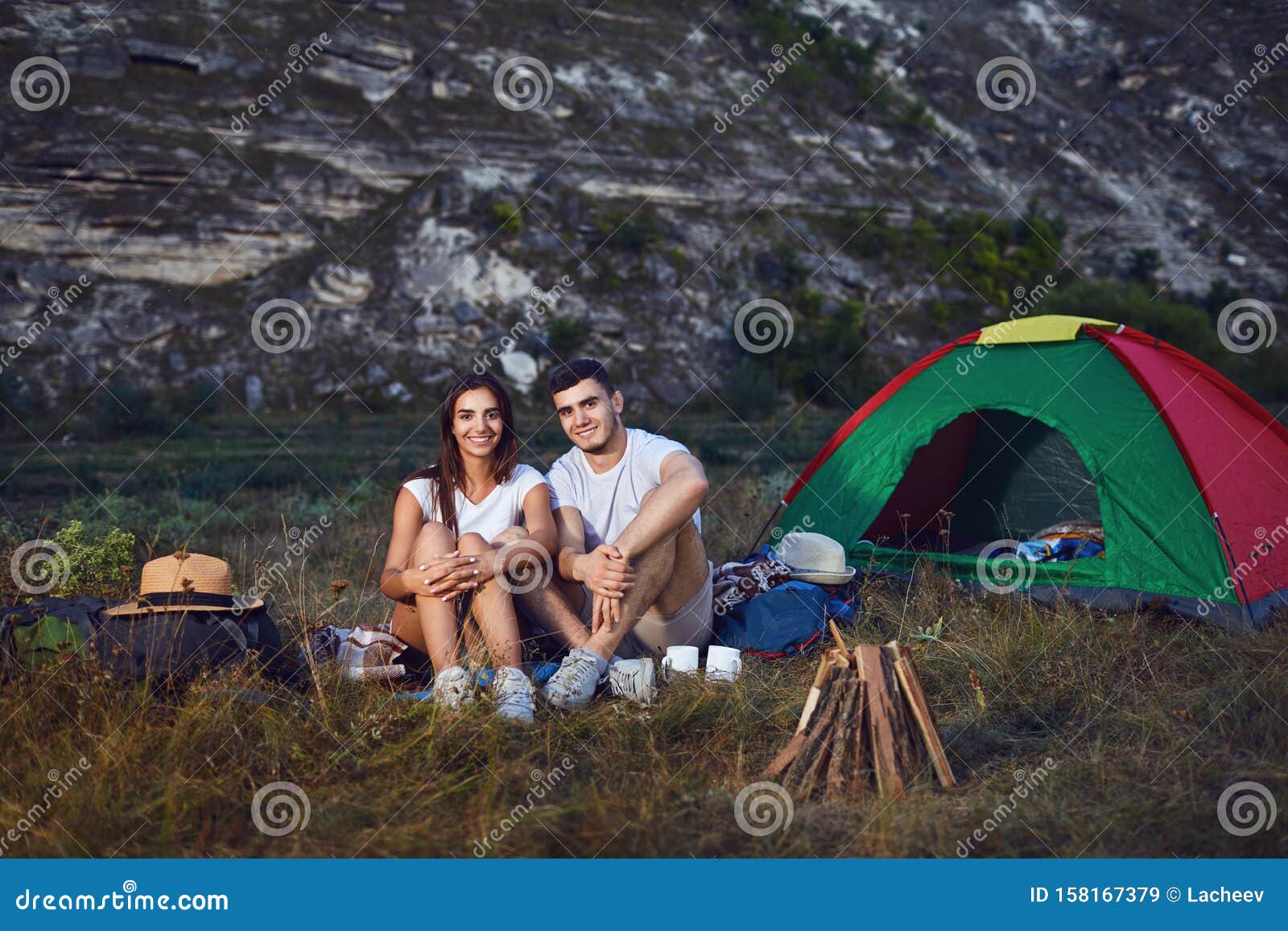 Camping RomÃ¡ntico. Una Pareja Joven Sentada Junto a La Hoguera Imagen de  archivo - Imagen de verano, campo: 158167379
